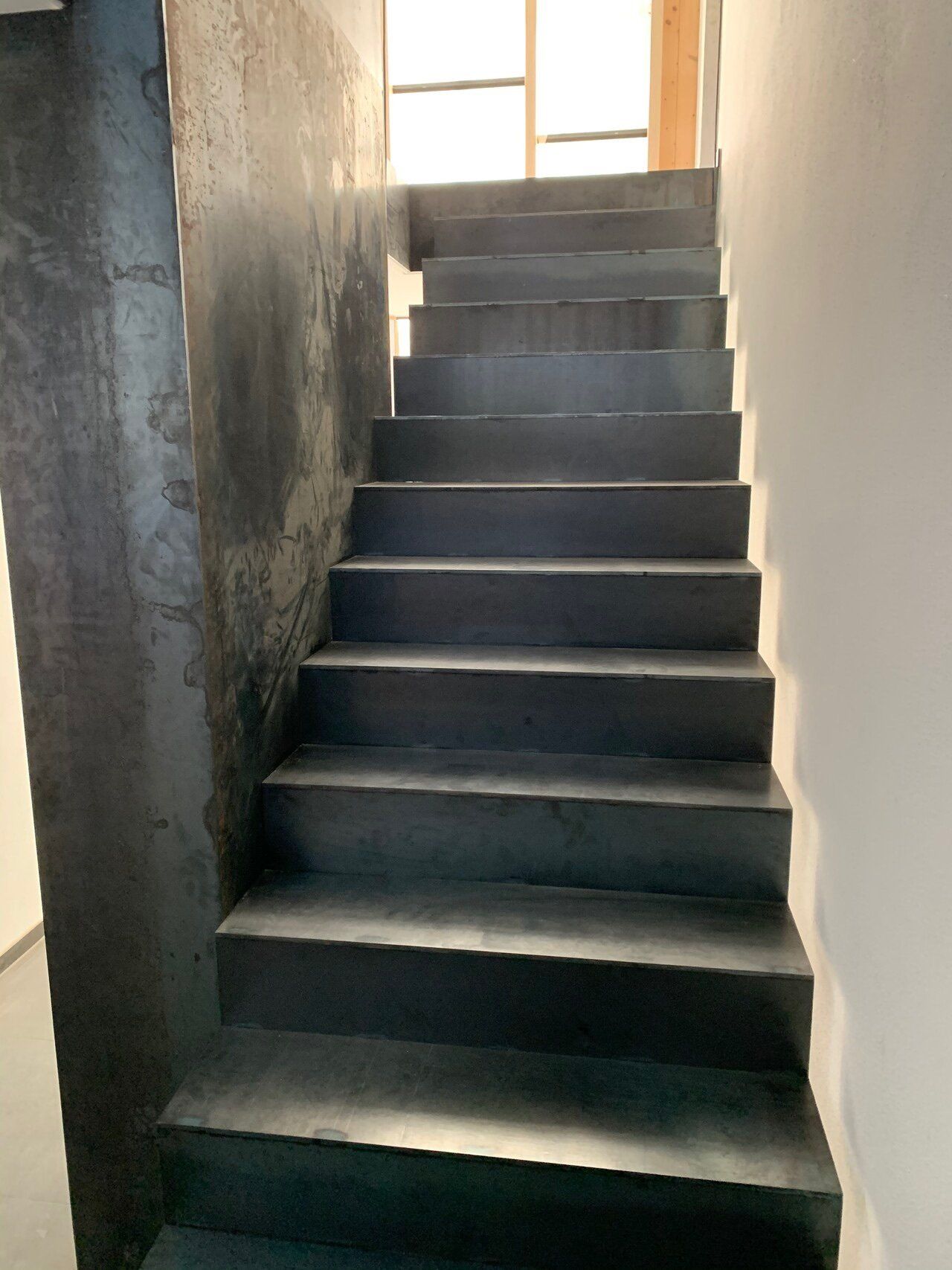 Eine Treppe, die zu einem Fenster in einem Gebäude führt.