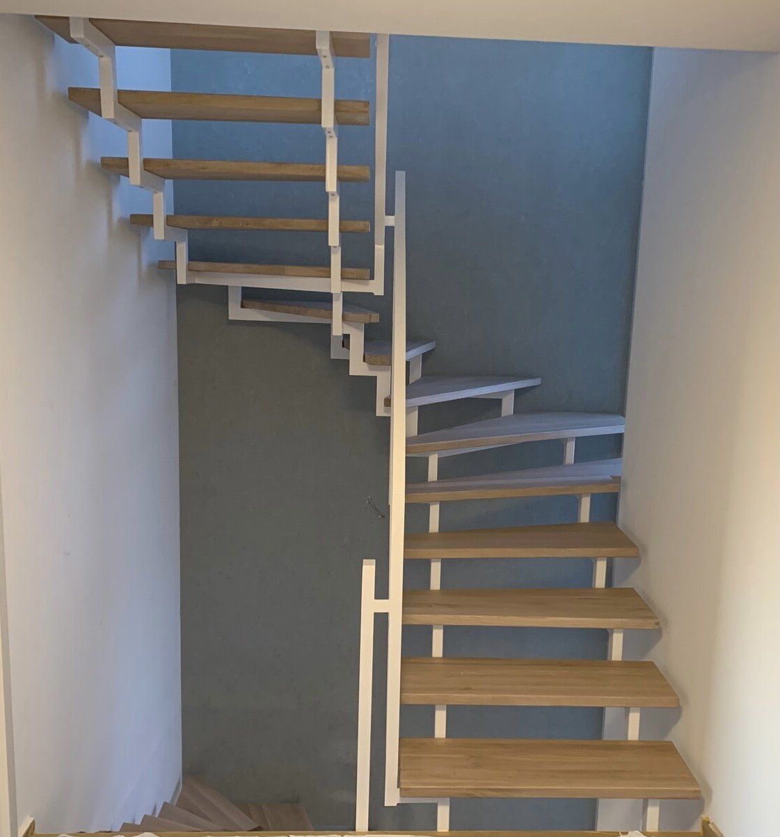 Eine Treppe mit Holzstufen und einem weißen Geländer
