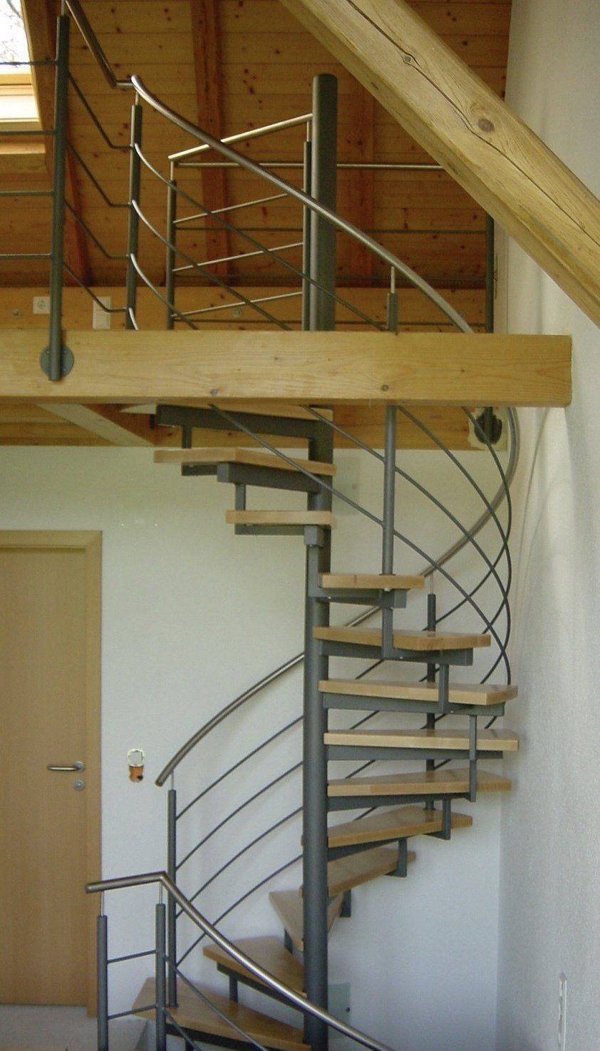 Eine Wendeltreppe mit Holzstufen und einem Metallgeländer