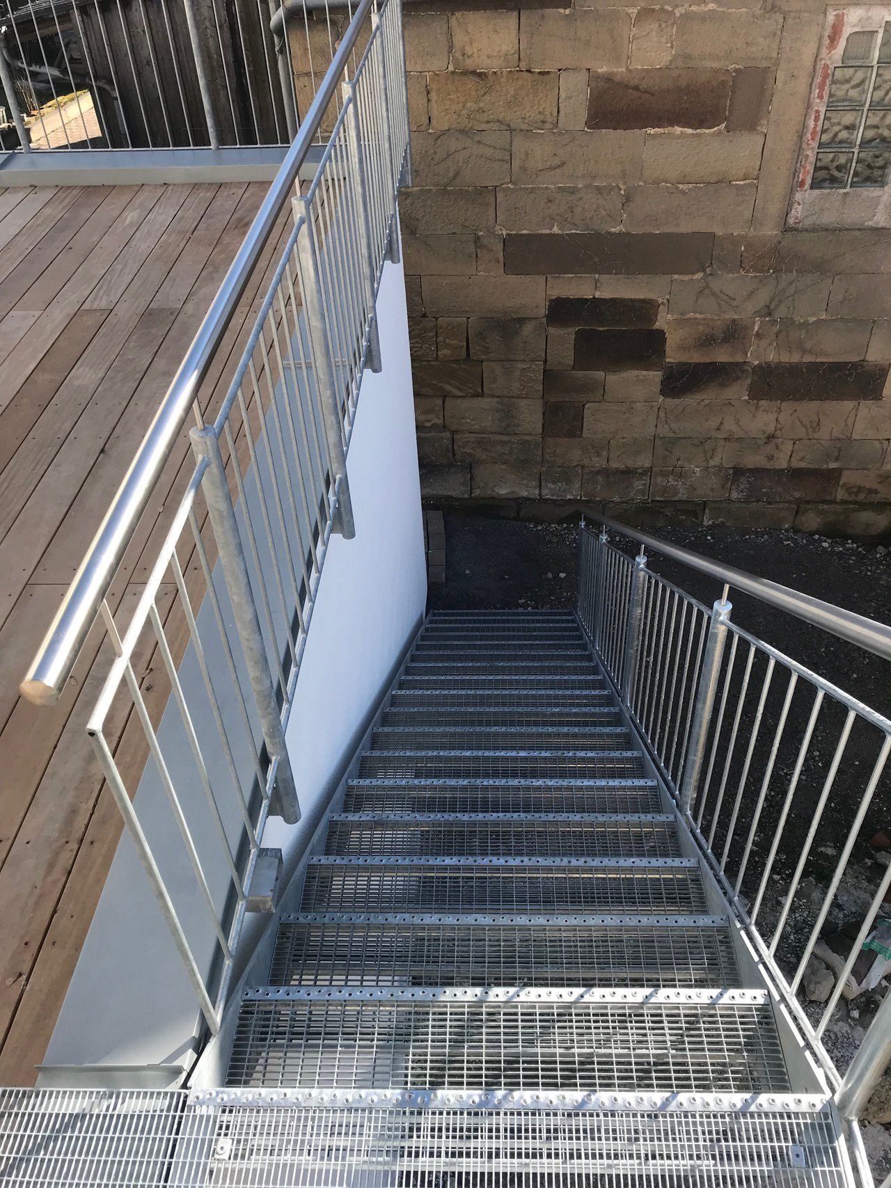 Eine Metalltreppe mit einem Holzdeck und einem Metallgeländer