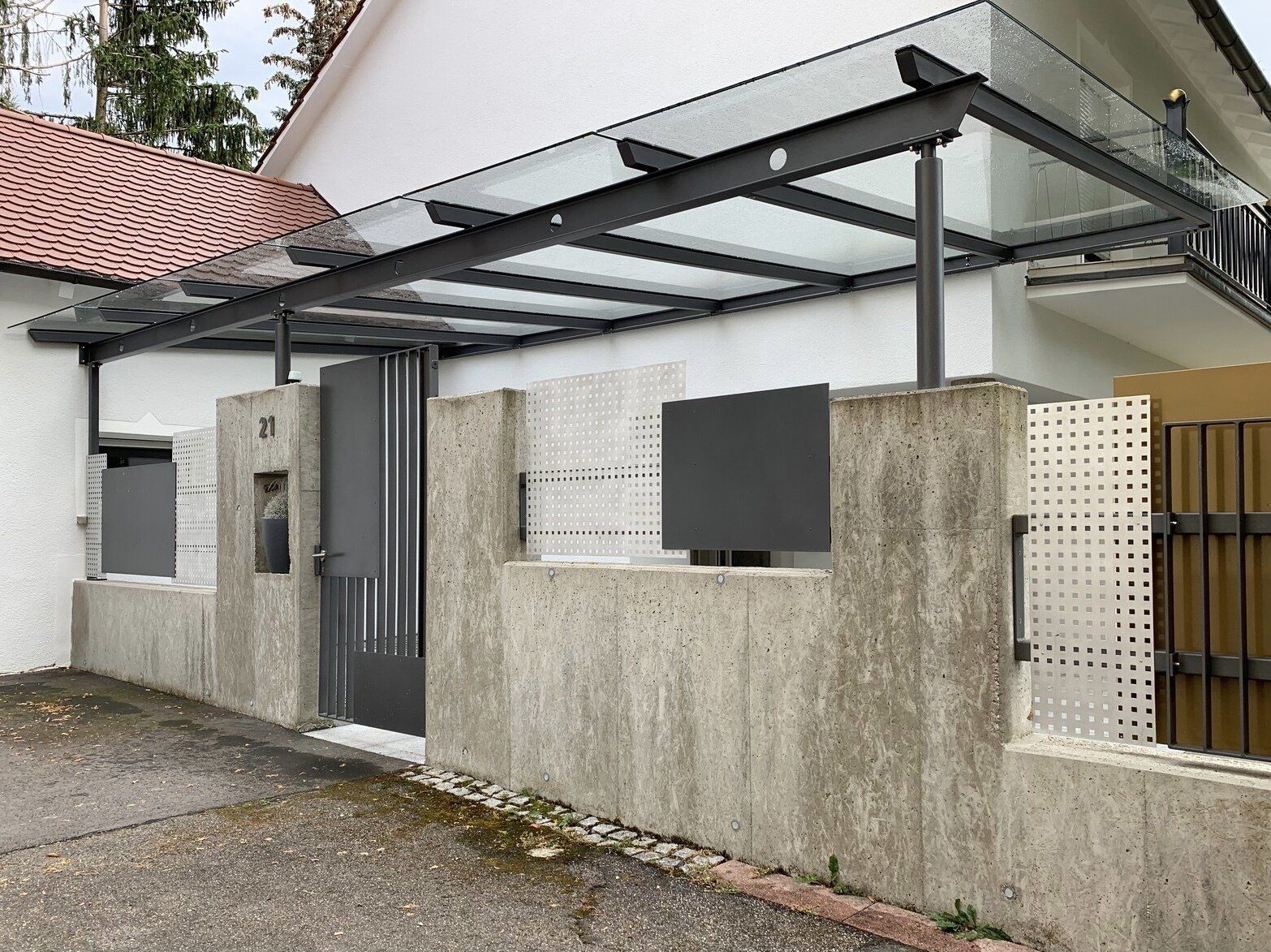 Ein weißes Haus mit einem Glasdach über der Tür