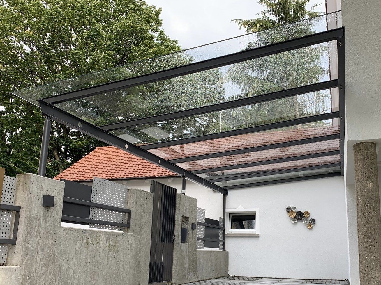 An der Seite eines Hauses ist ein Glasdach angebracht.