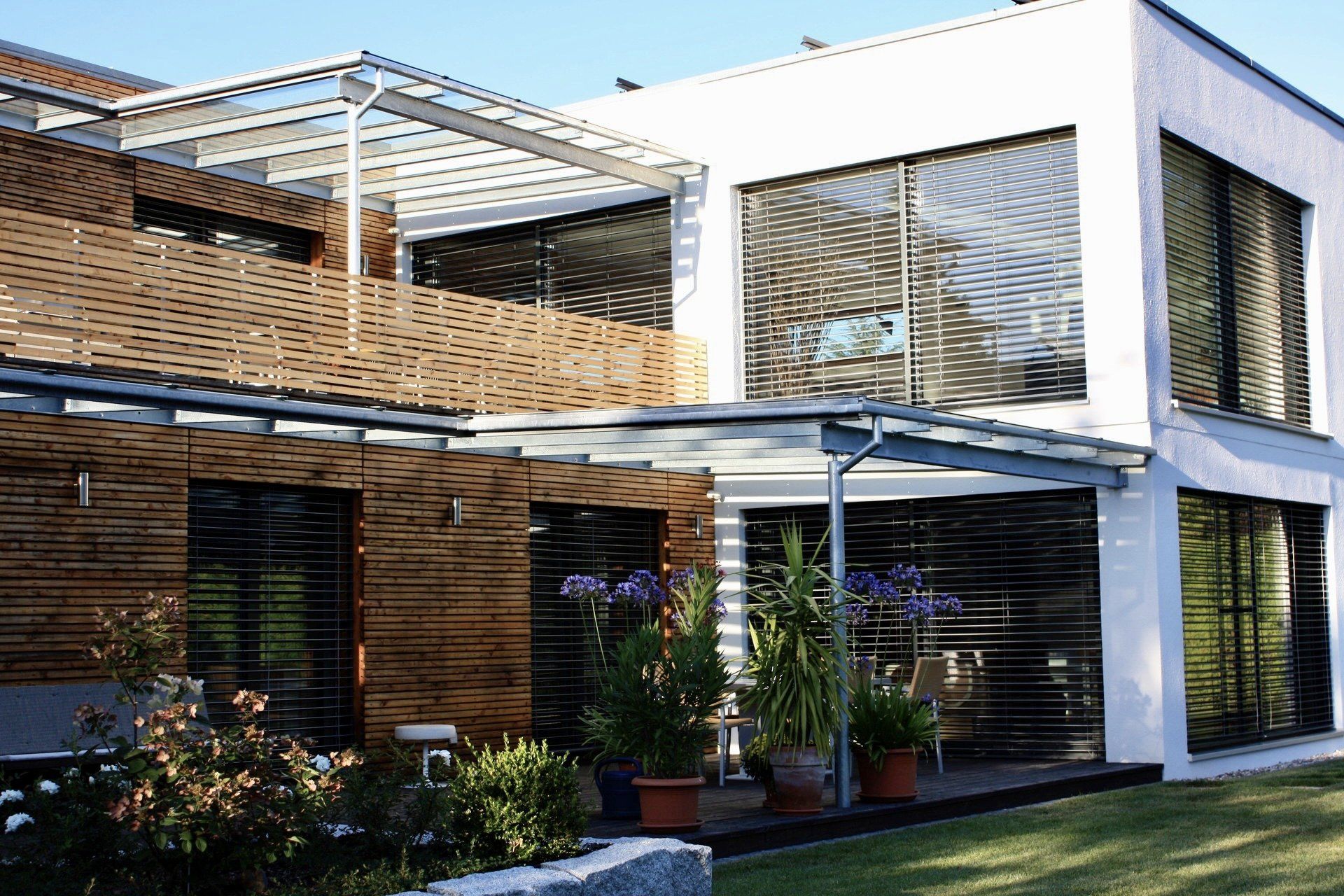 Ein Haus mit vielen Fenstern und einer Pergola