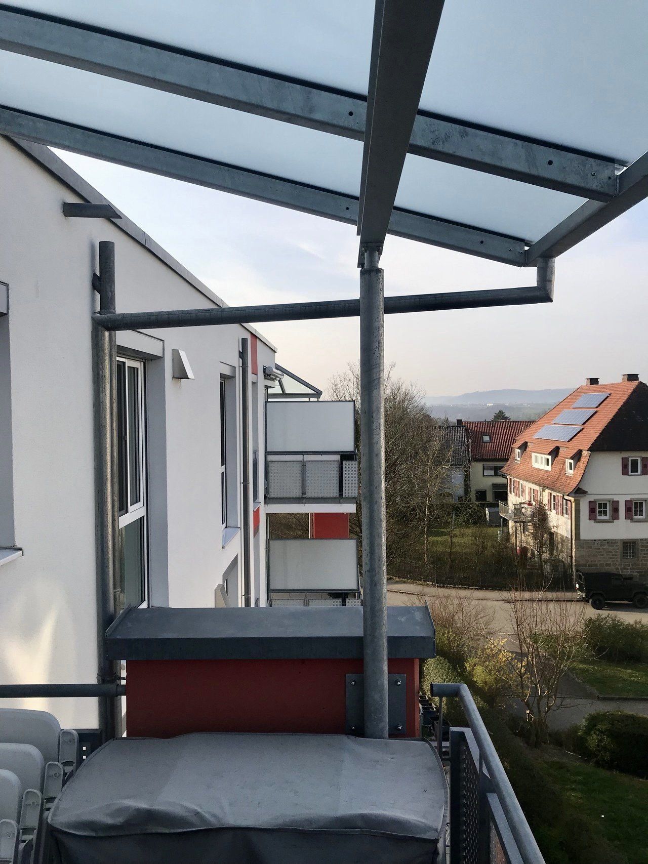 Ein Balkon mit einem Glasdach darüber