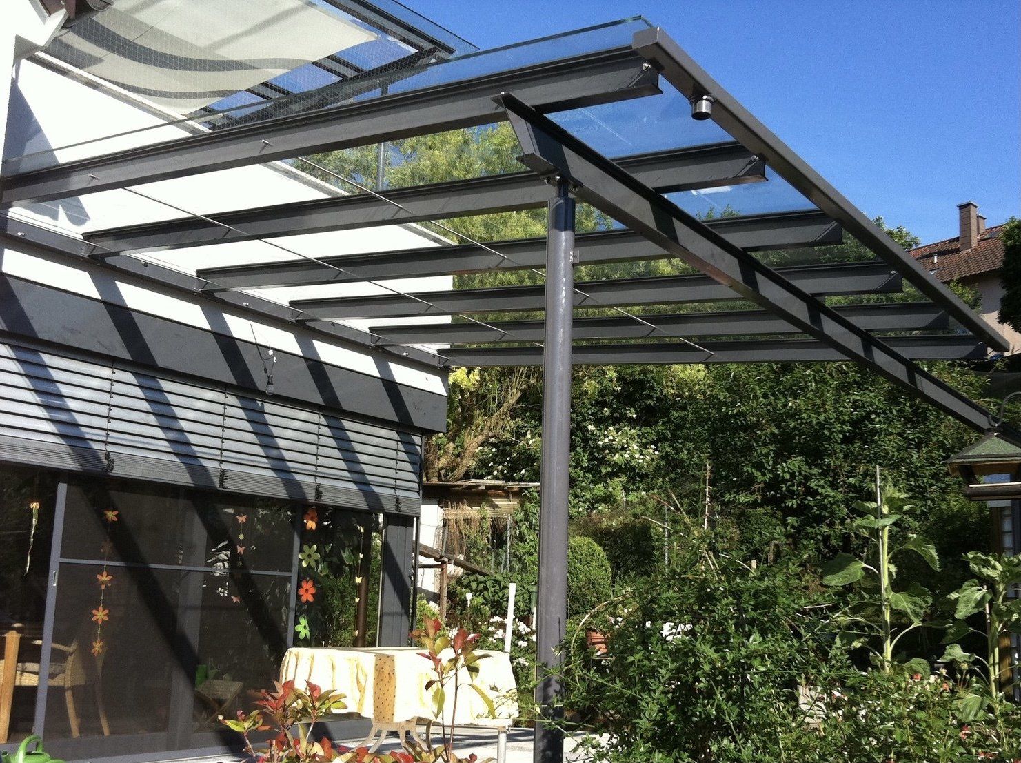 Eine Terrasse mit einem Baldachin darüber und Bäumen im Hintergrund