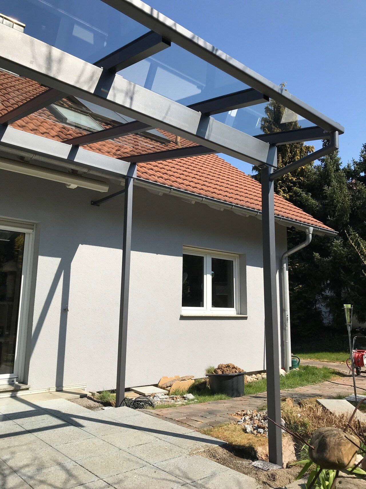 Ein weißes Haus mit einem Glasdach an der Seite