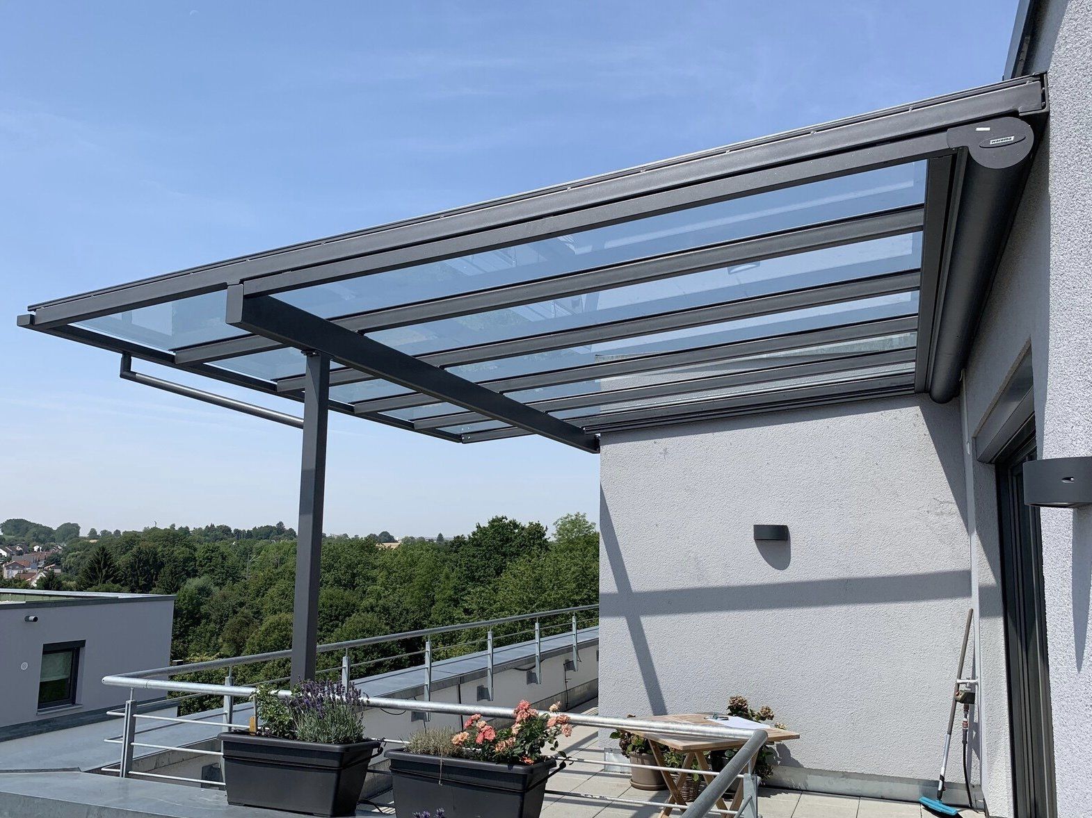 Ein Balkon mit einem Vordach und Pflanzgefäßen darauf