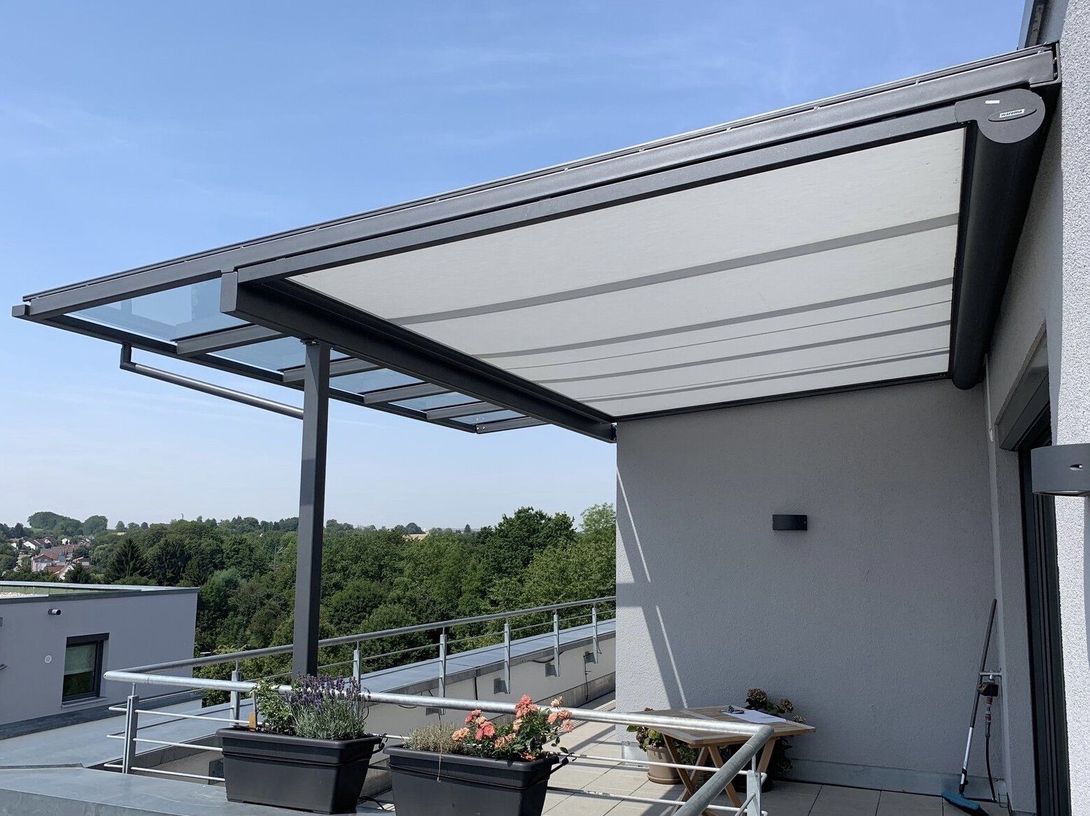 Ein Balkon mit einem Baldachin und Pflanzgefäßen darauf.