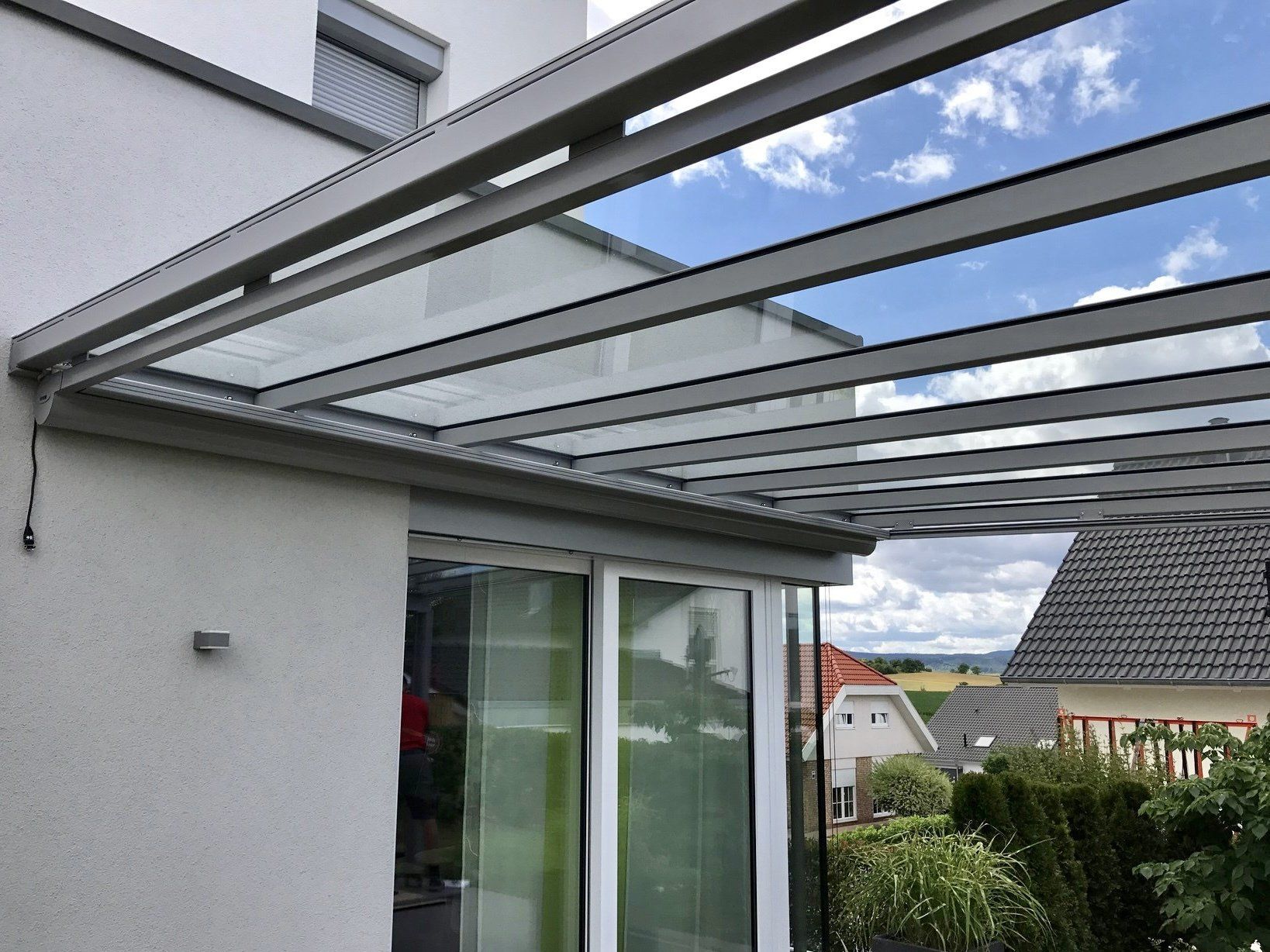 Ein Haus mit einem Glasdach und einer Glasschiebetür.