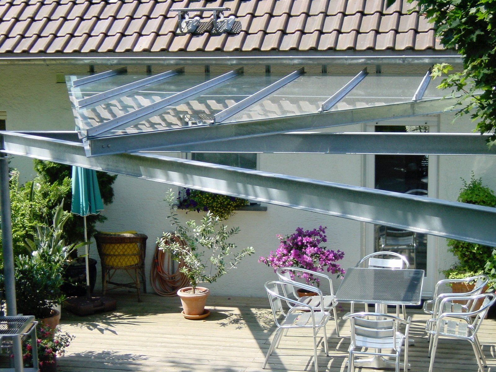 Eine Terrasse mit Tisch und Stühlen unter einem Baldachin