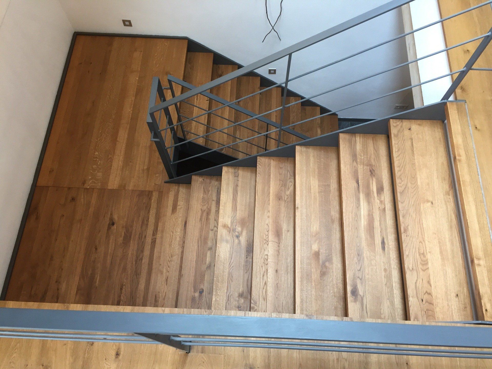 Eine Holztreppe mit Metallgeländer und Holzboden.