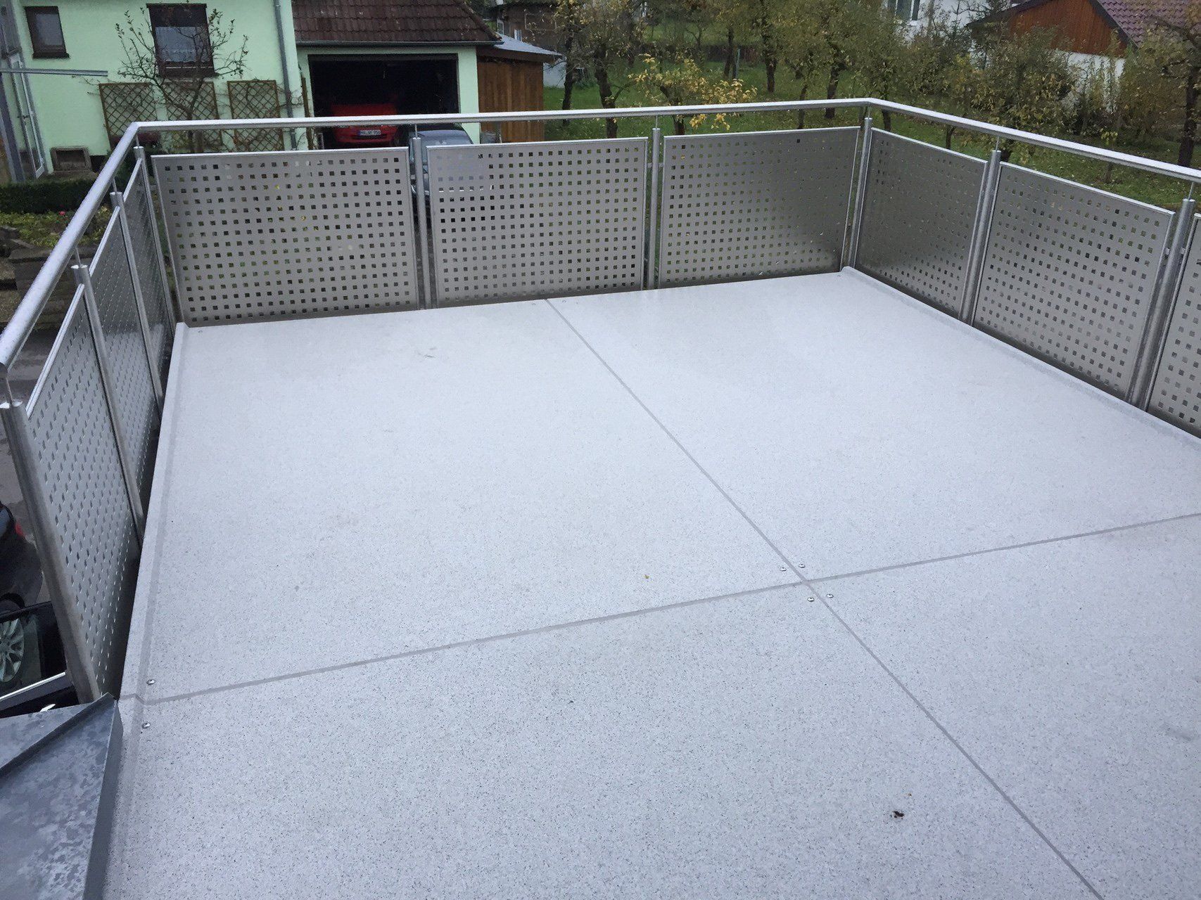 Ein Balkon mit Edelstahlgeländer und Betonboden