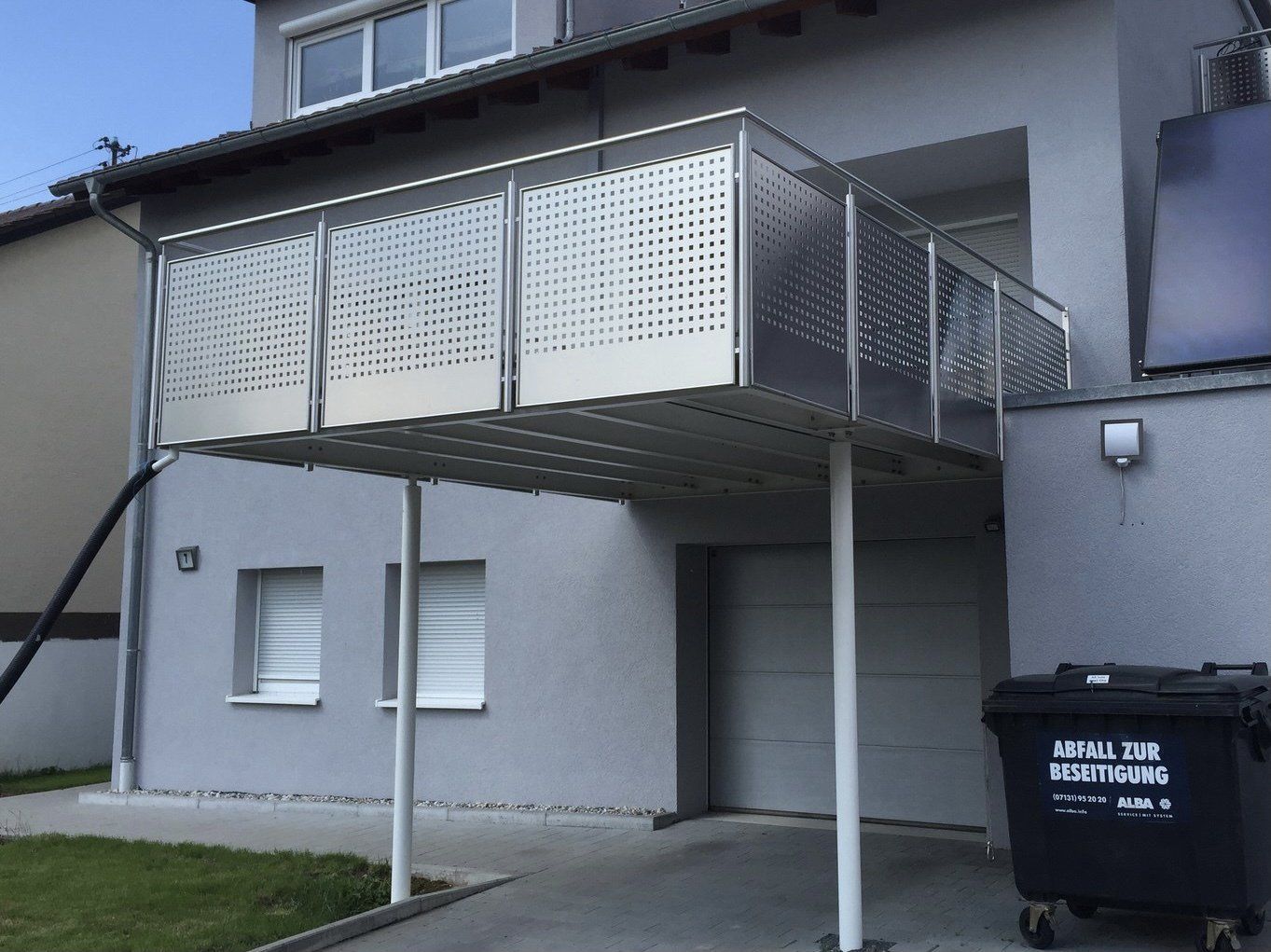 Ein Haus mit einem Balkon und einem Mülleimer mit der Aufschrift „Achtung“ darauf