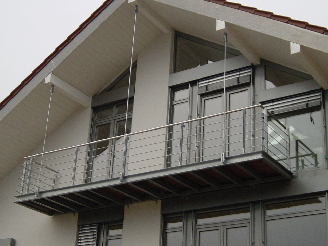 Ein Balkon an der Seite eines Gebäudes mit einem Geländer aus Edelstahl