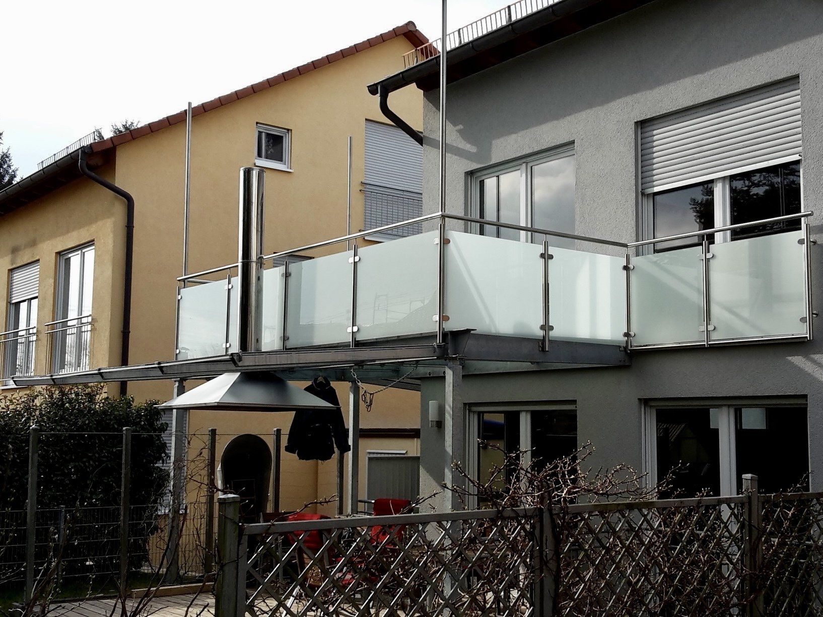 Ein Haus mit Balkon und einem Zaun davor