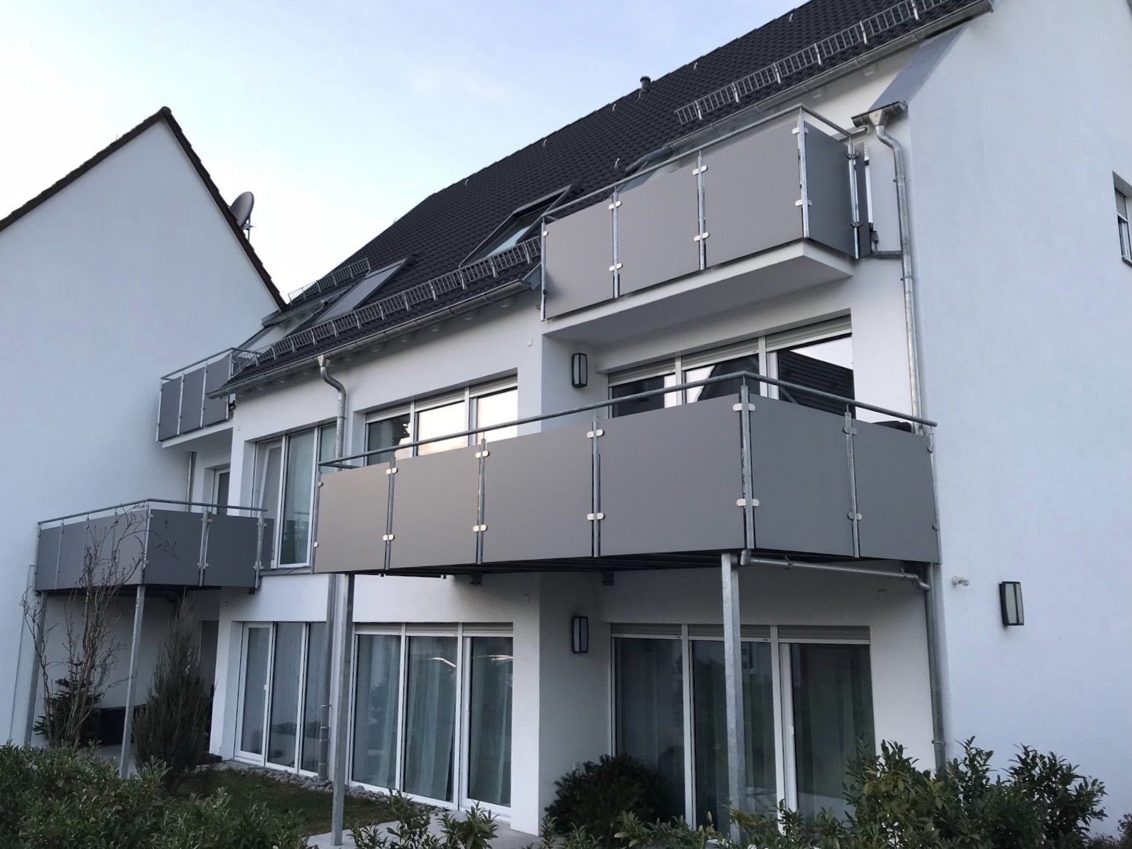 Ein weißes Gebäude mit einem Balkon im zweiten Stock