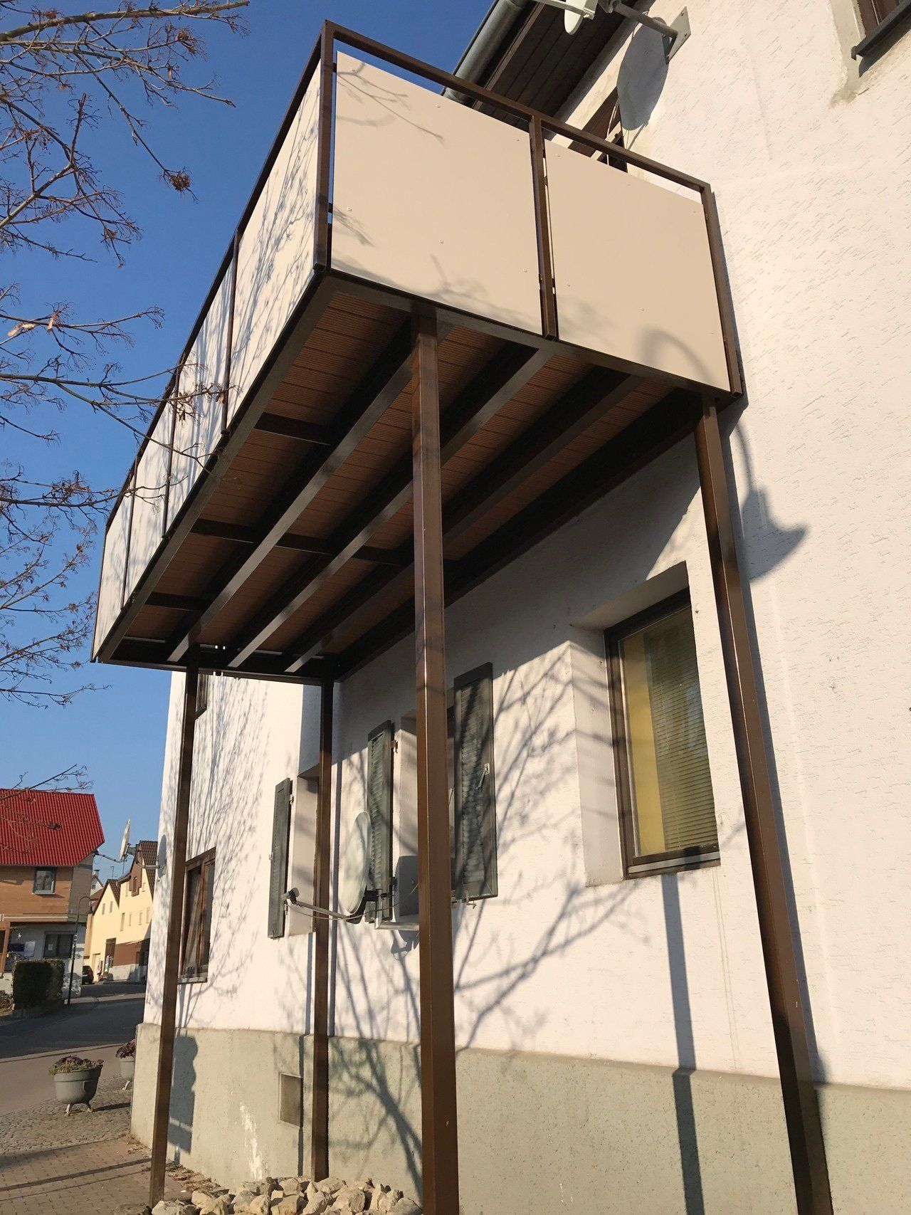 Ein weißes Gebäude mit einem Balkon an der Seite