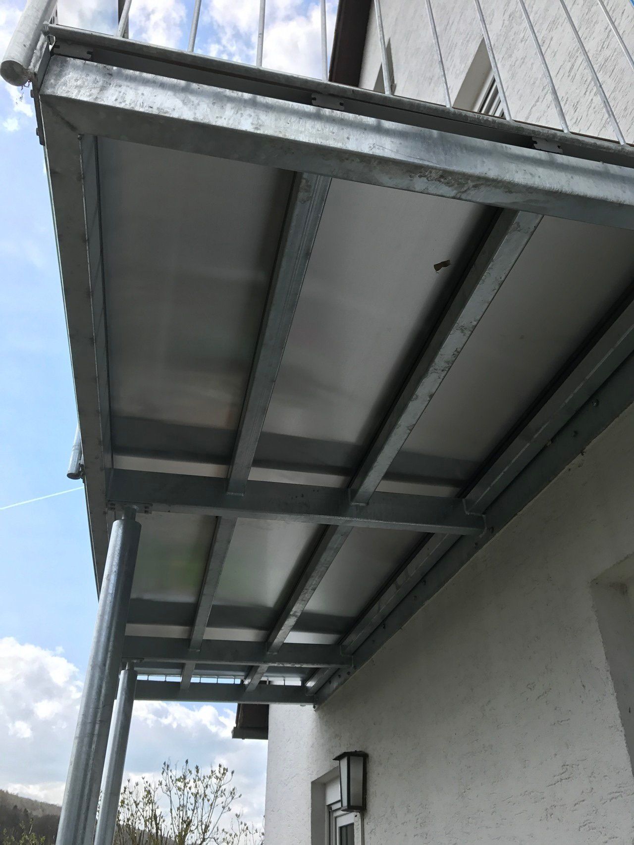 Ein Balkon an der Seite eines Gebäudes mit einem blauen Himmel im Hintergrund