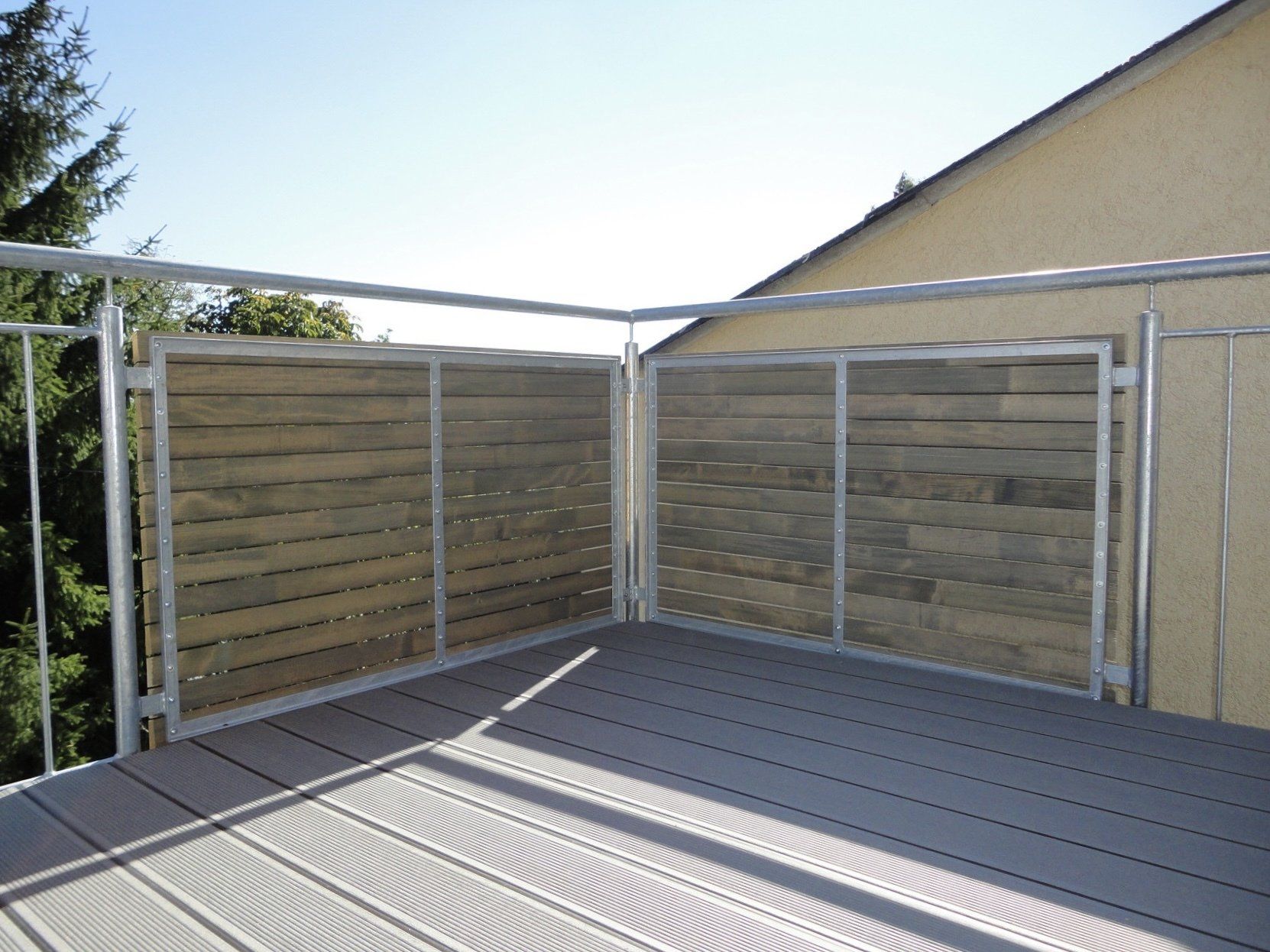 Ein Balkon mit einem Holzzaun und einem Metallgeländer