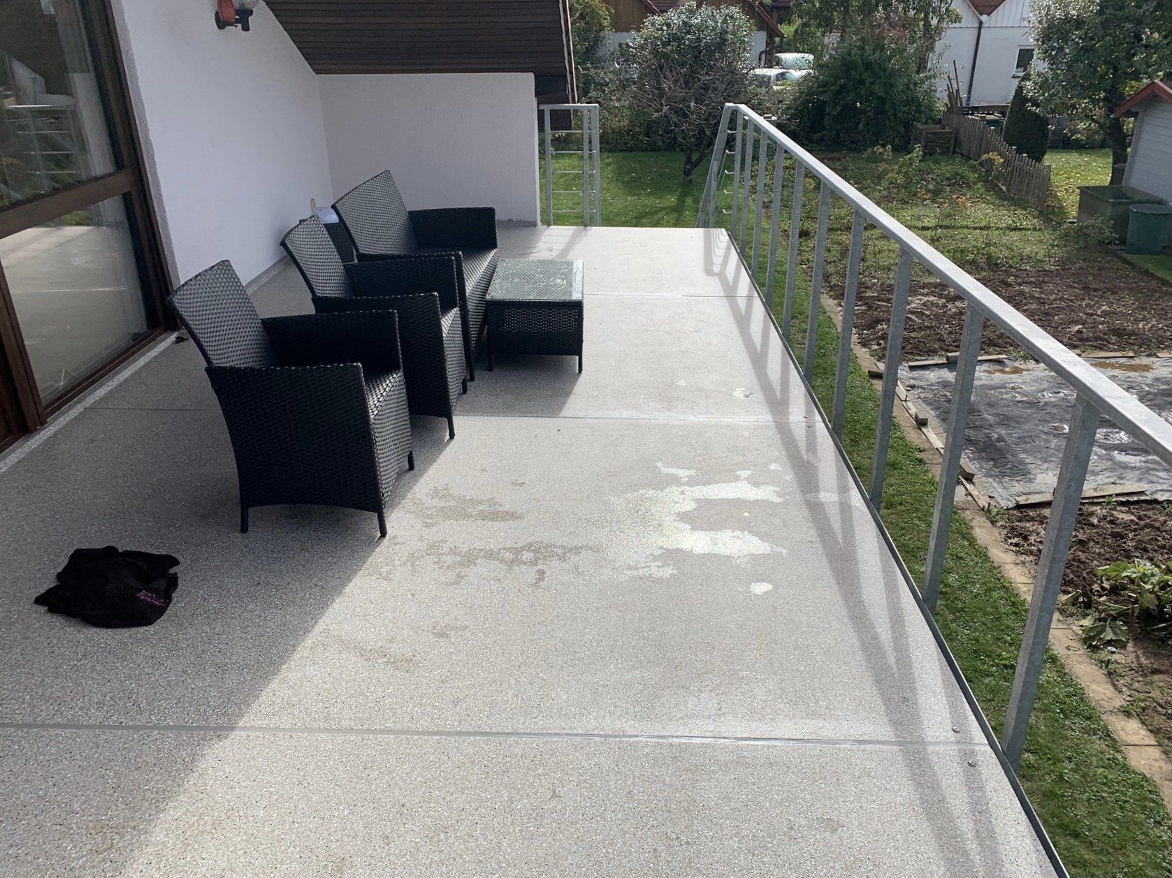 Eine Terrasse mit Sofa, Stühlen und Tisch.