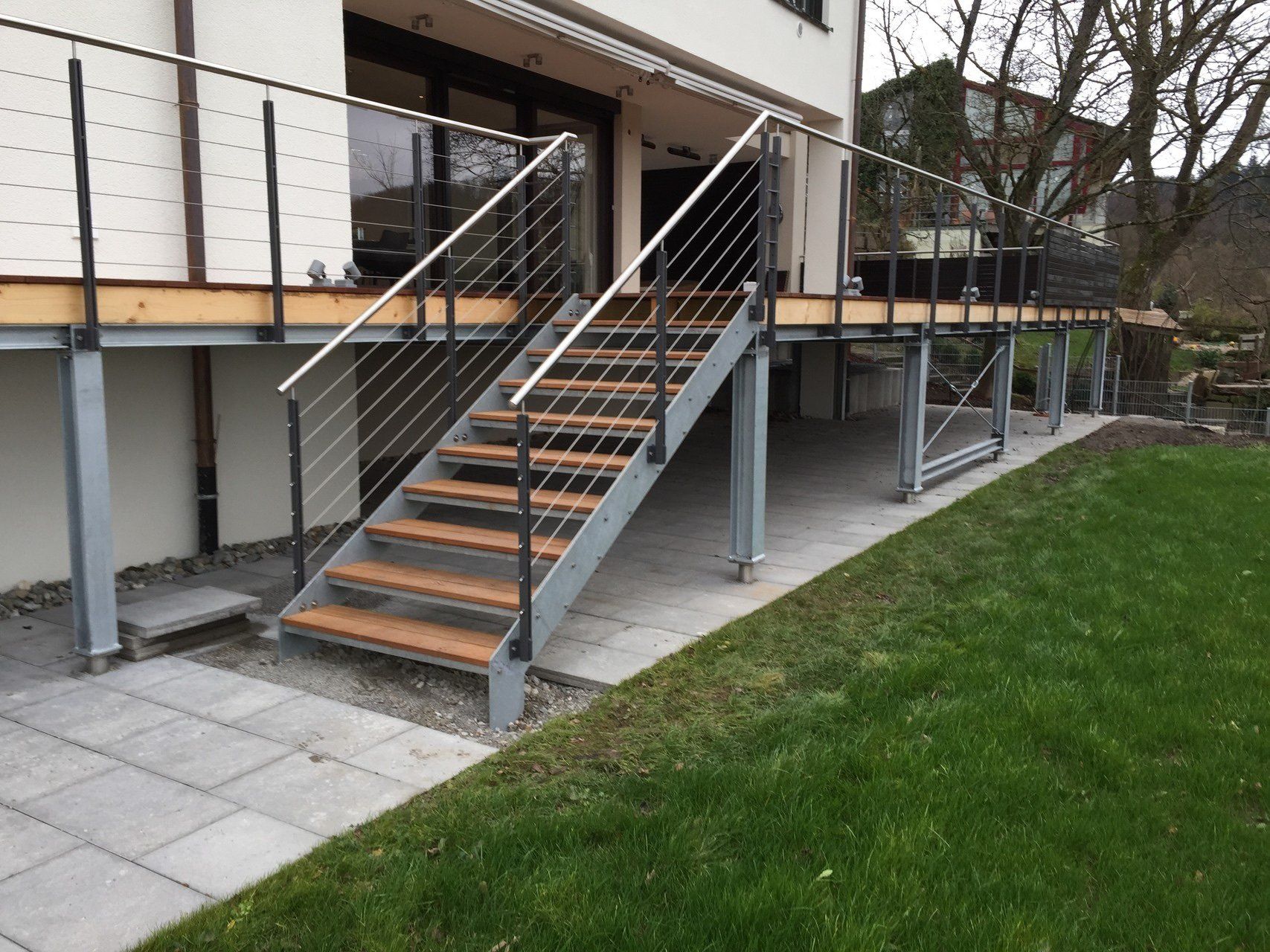 Eine Treppe, die zu einem Deck mit einem Geländer aus Edelstahl führt