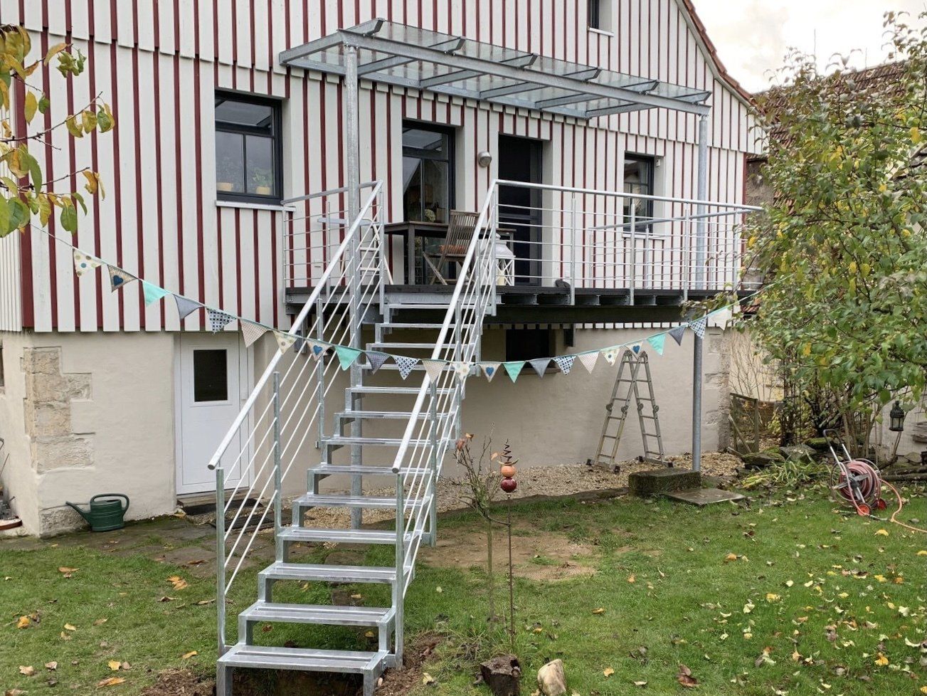 Eine Metalltreppe führt zu einem Balkon an der Seite eines Hauses.