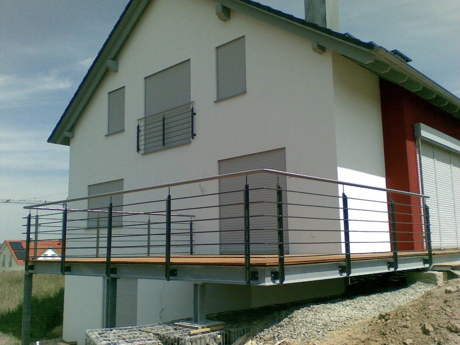 Ein weißes Haus mit einem Balkon an der Seite