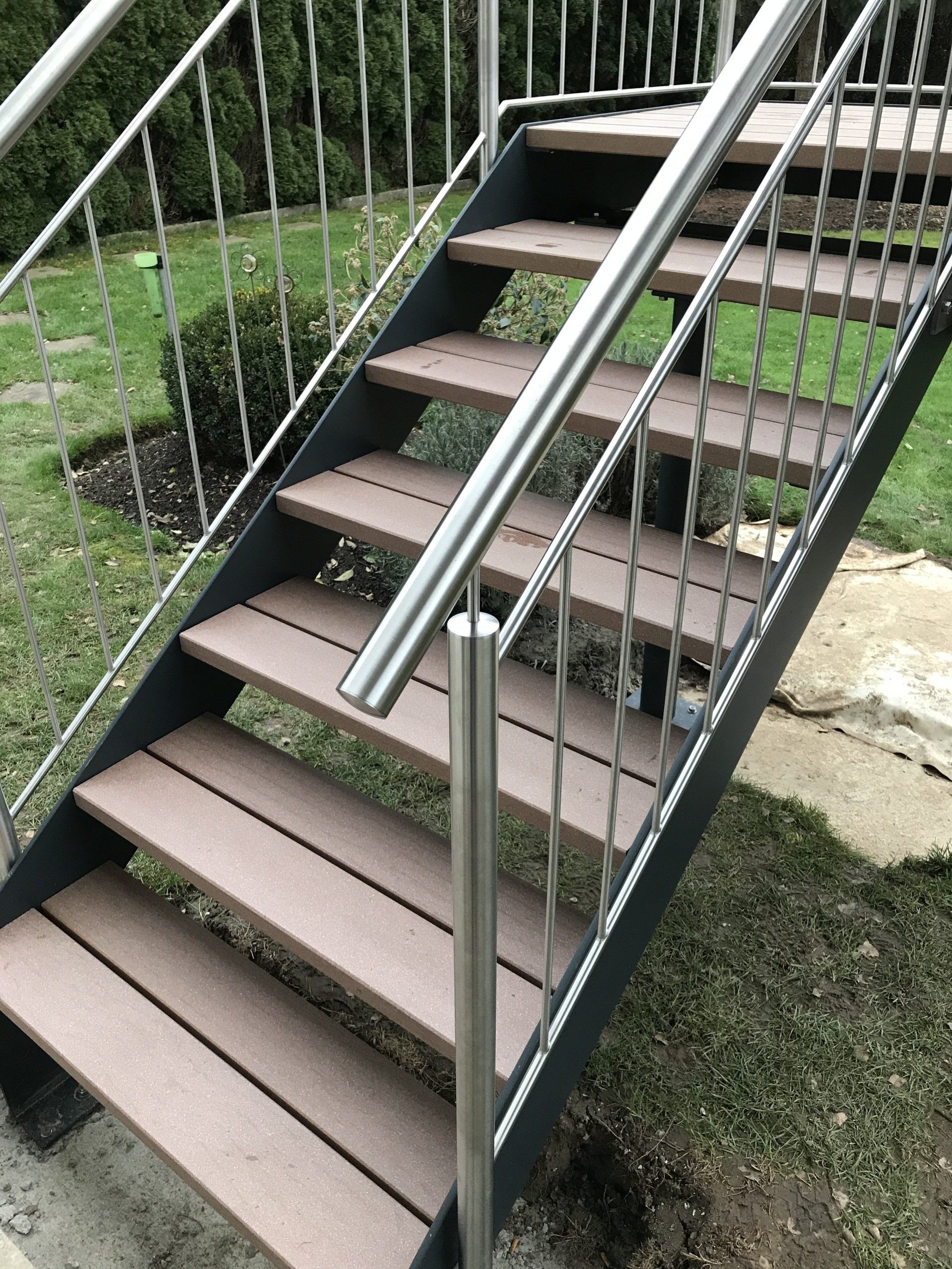 Eine Reihe von Holztreppen mit einem Geländer aus Edelstahl