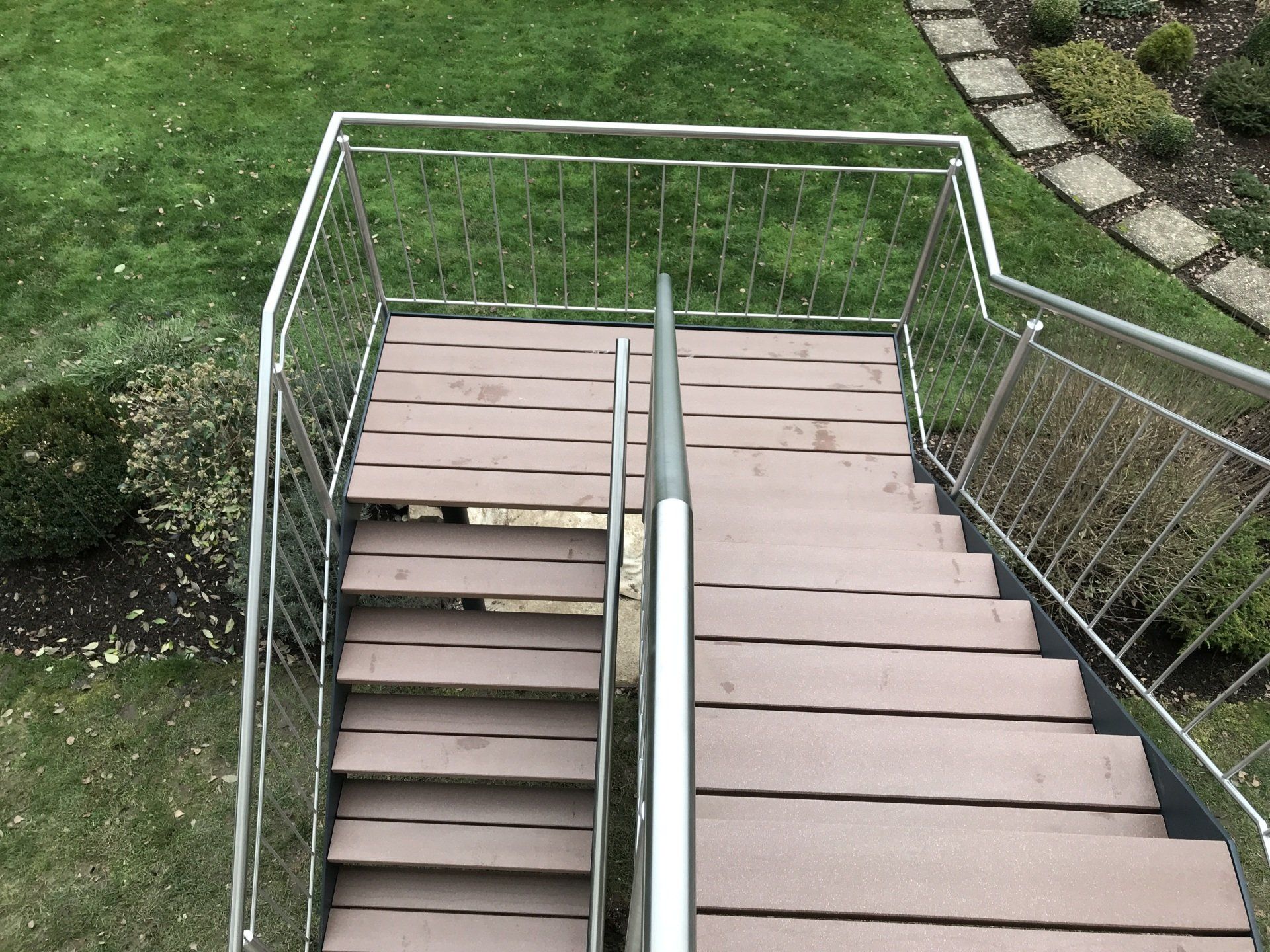 Eine Reihe von Holztreppen mit einem Geländer aus Edelstahl