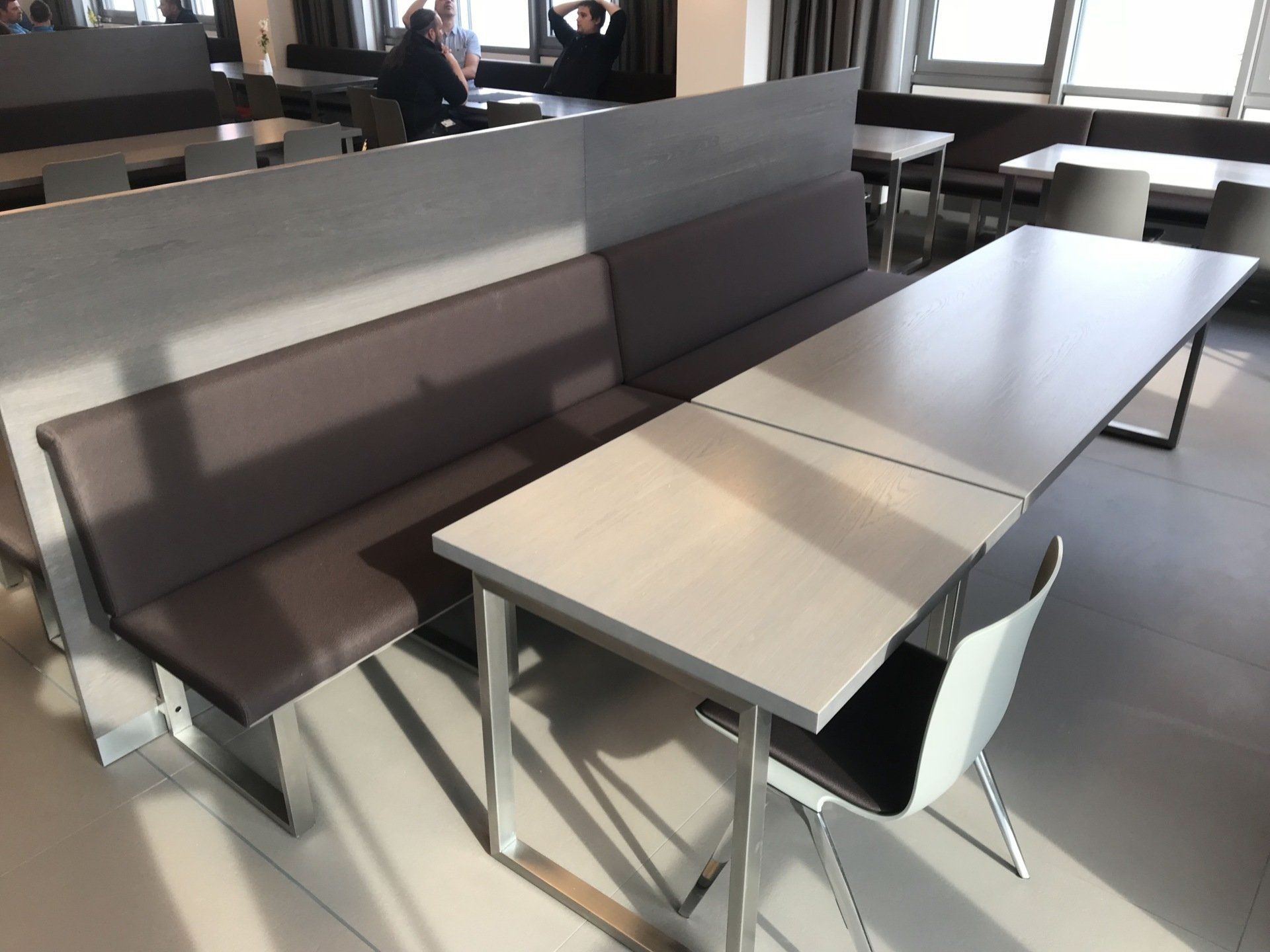 Ein Esszimmer mit Tischen und Stühlen und einer Bank