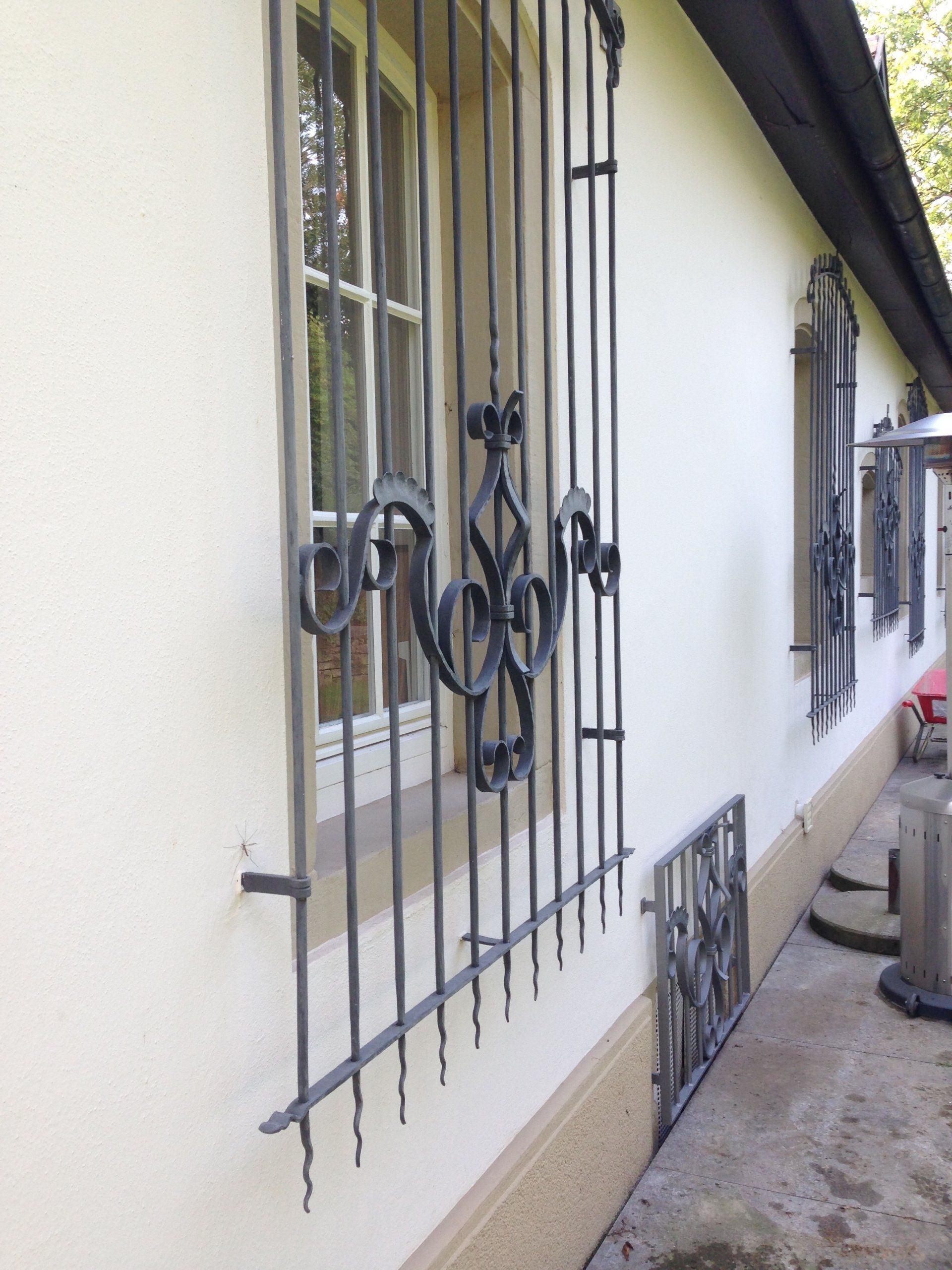 Ein weißes Gebäude mit schmiedeeisernen Gittern an den Fenstern