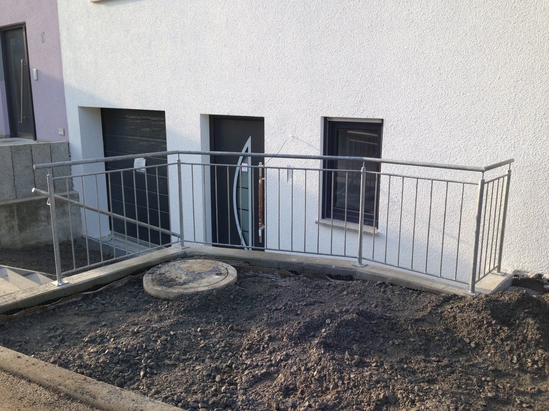 Ein weißes Gebäude mit einem Metallgeländer an der Seite.