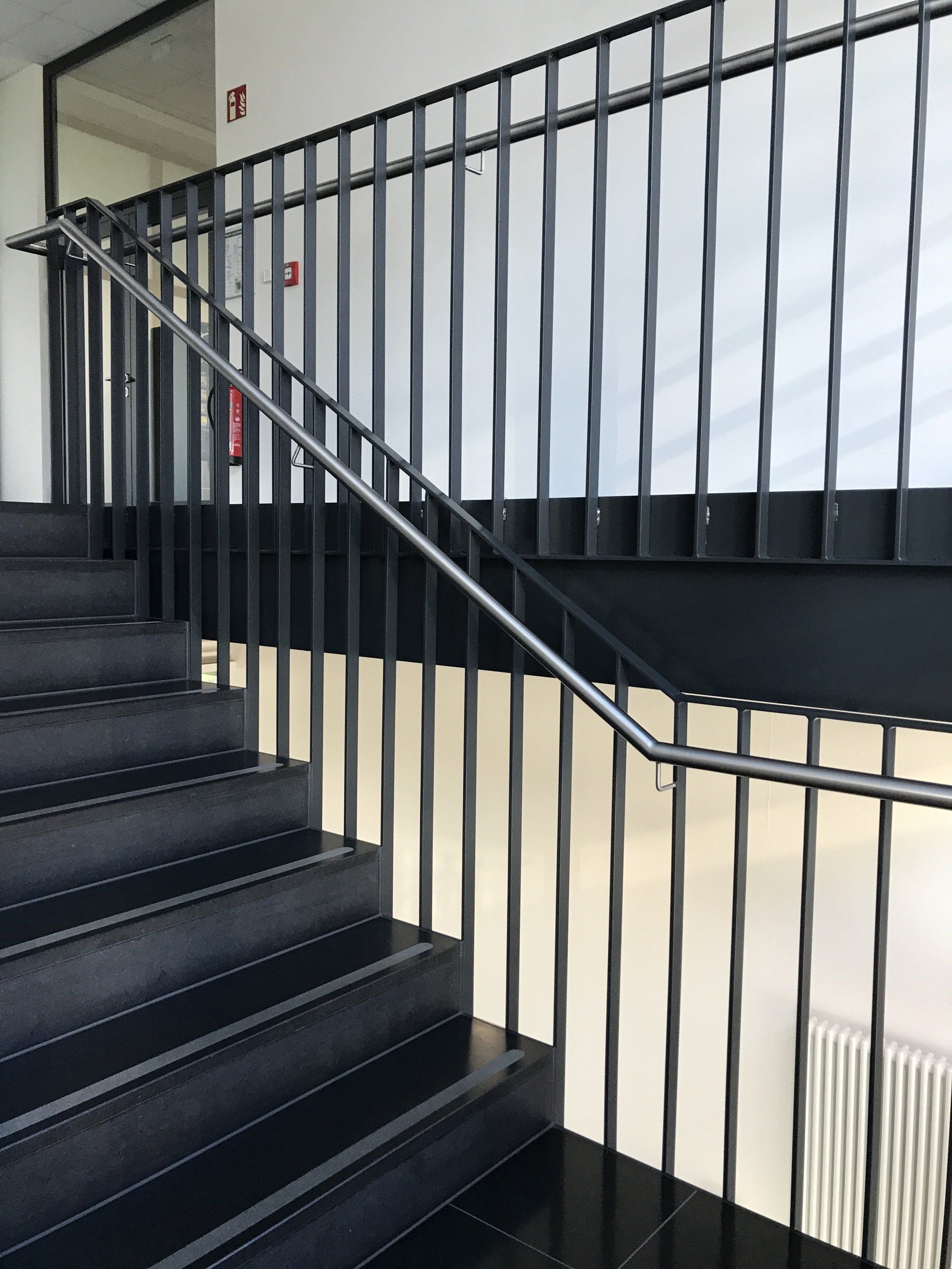 Eine schwarze Treppe mit einem Metallgeländer in einem Gebäude