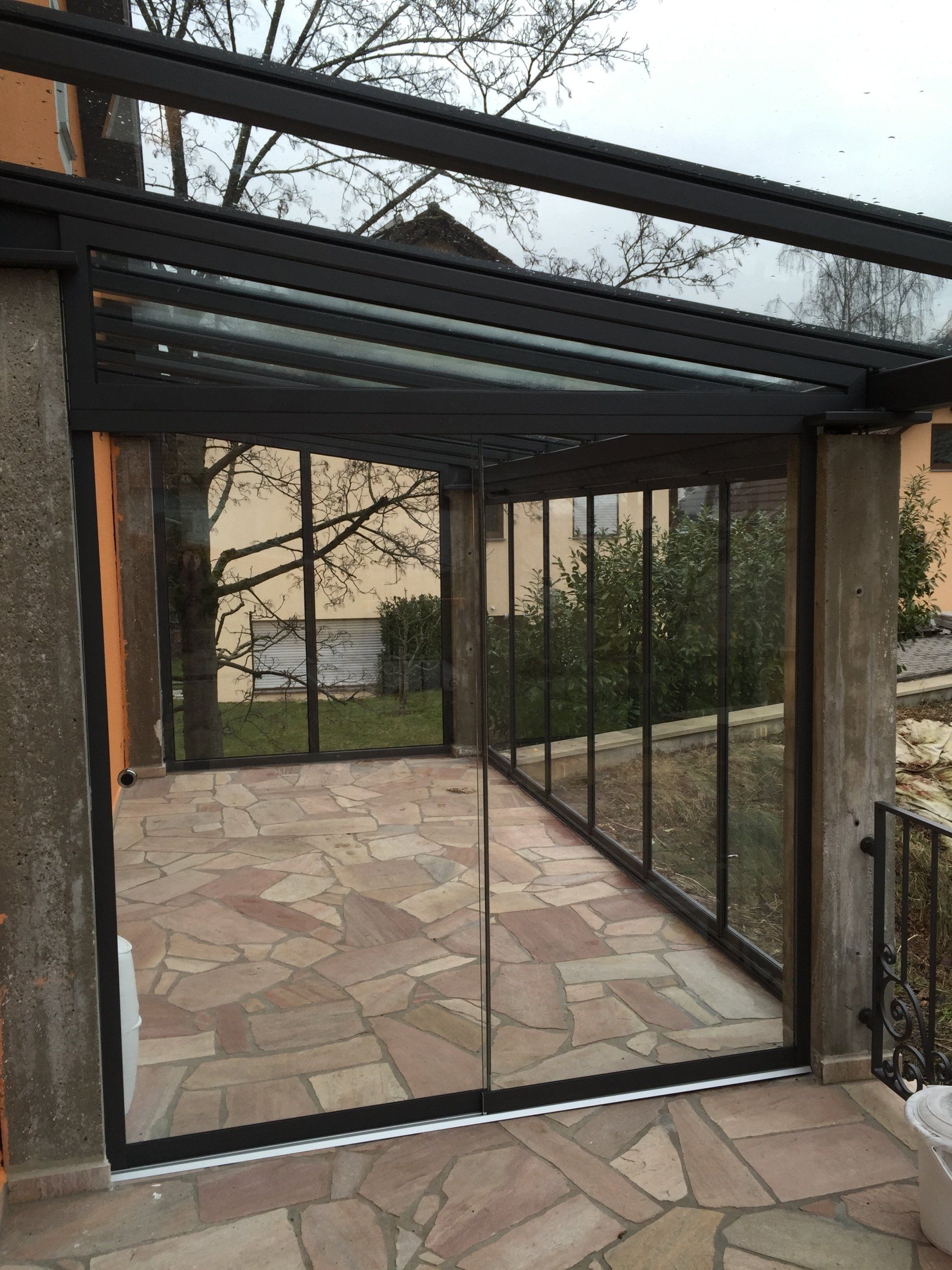 Ein Raum mit vielen Fenstern und einem Ziegelboden