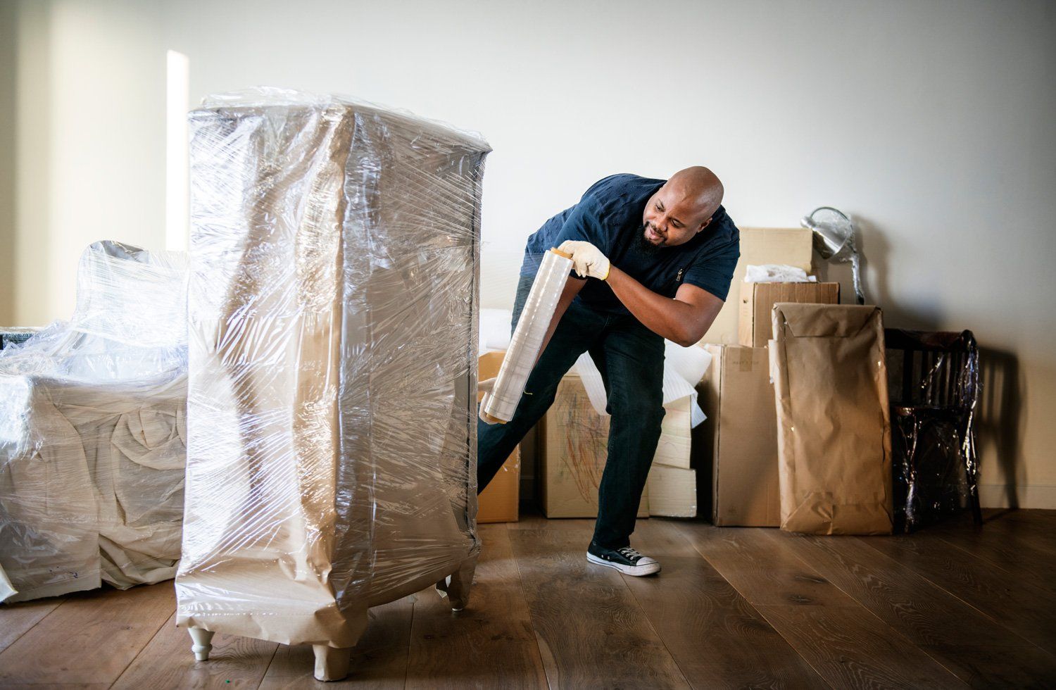 Man Wrapping Cabinet — Los Angeles, CA — Superior Economy Moving