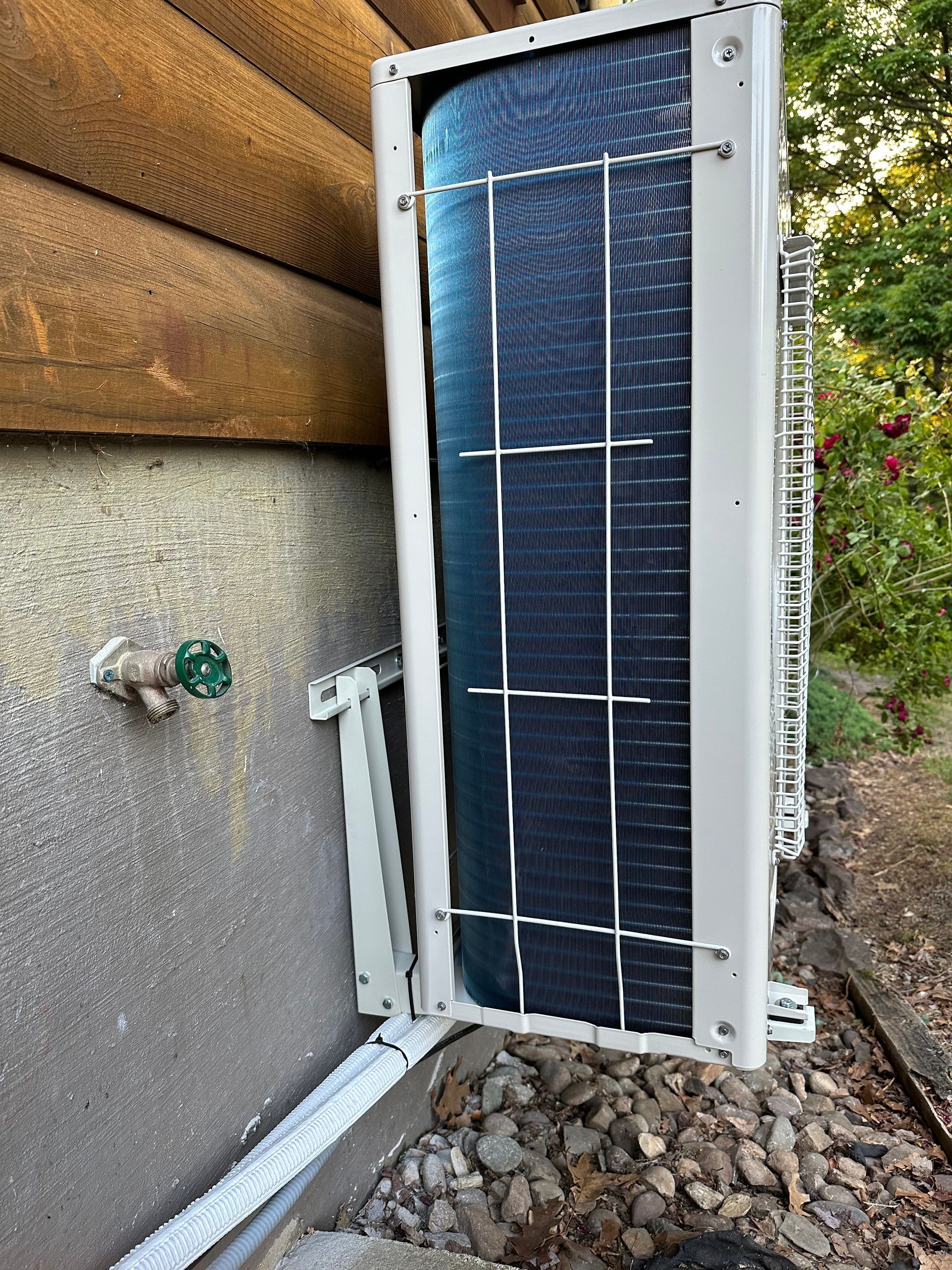 An outdoor air conditioning unit mounted on a log cabin wall.
