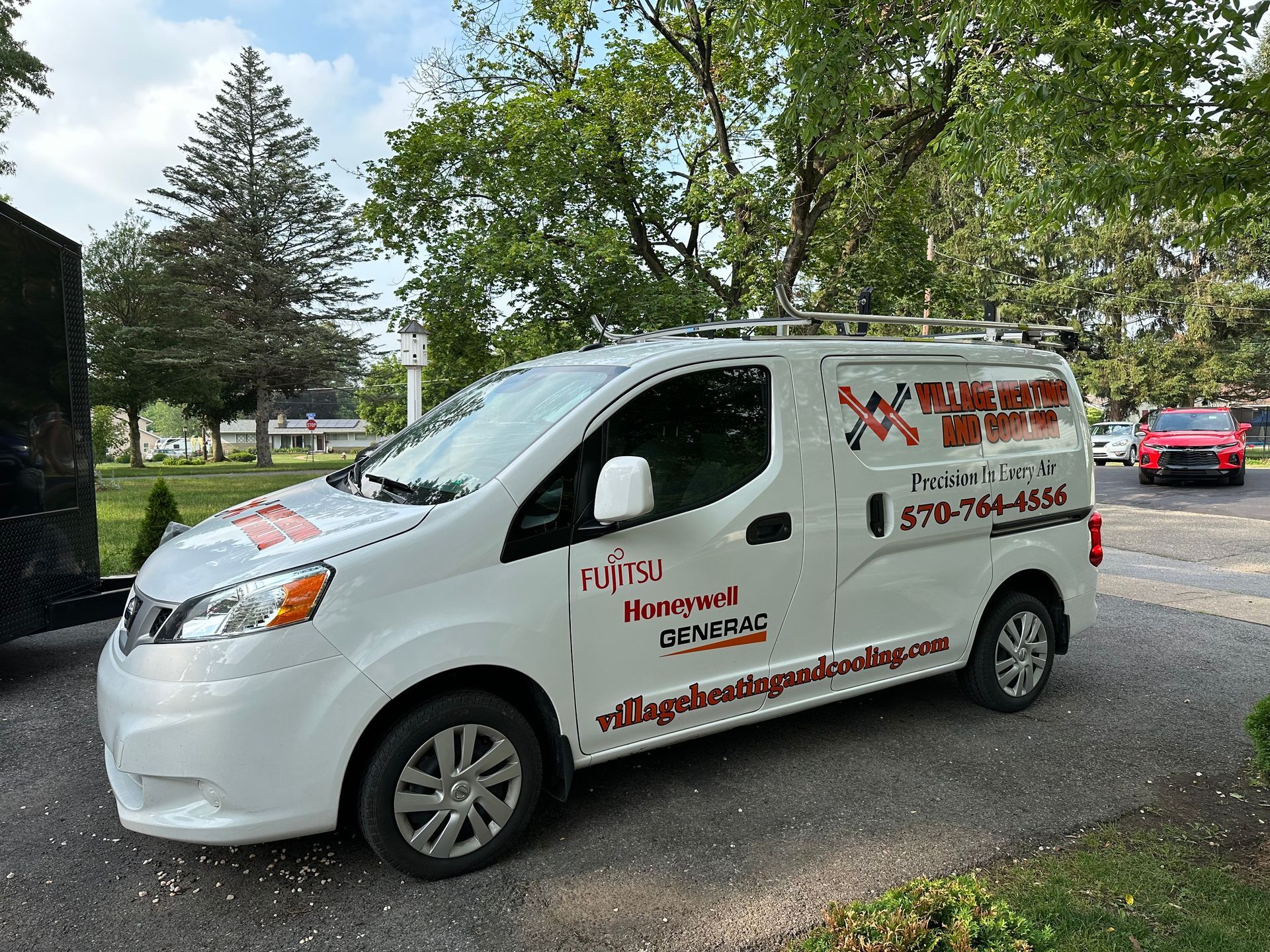 White service van with company logo parked outside; trees in background.