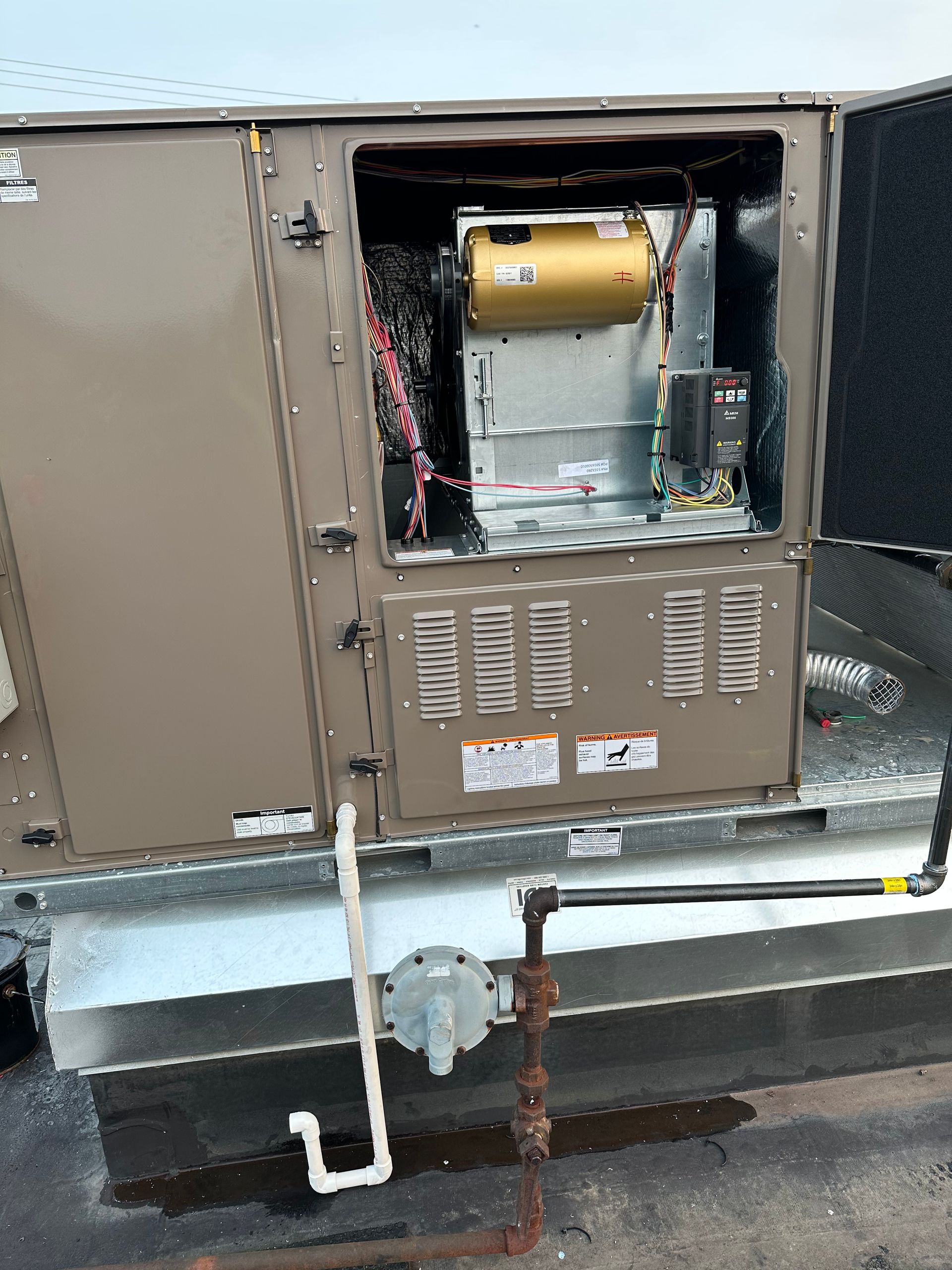 HVAC unit on a rooftop, open to reveal internal components, including a blower and wiring.