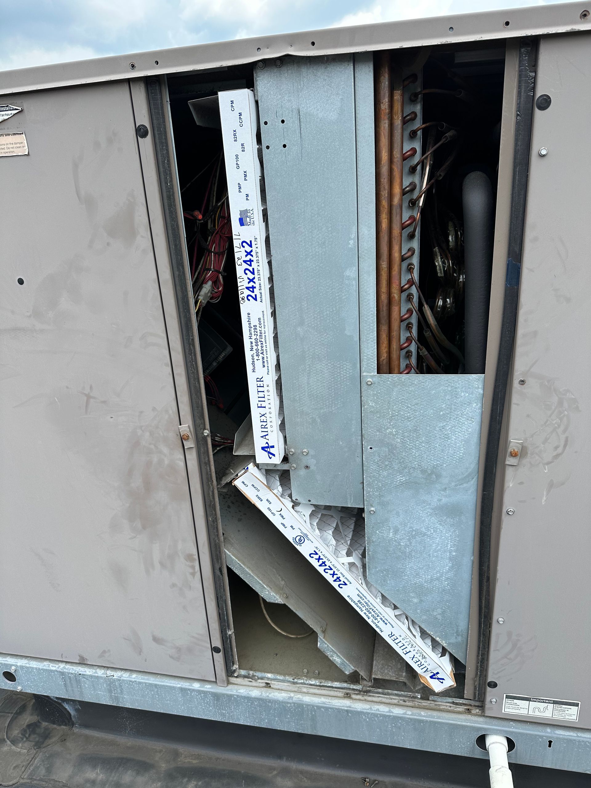 HVAC unit with open access panel, revealing internal components. Includes ducting and copper coils.