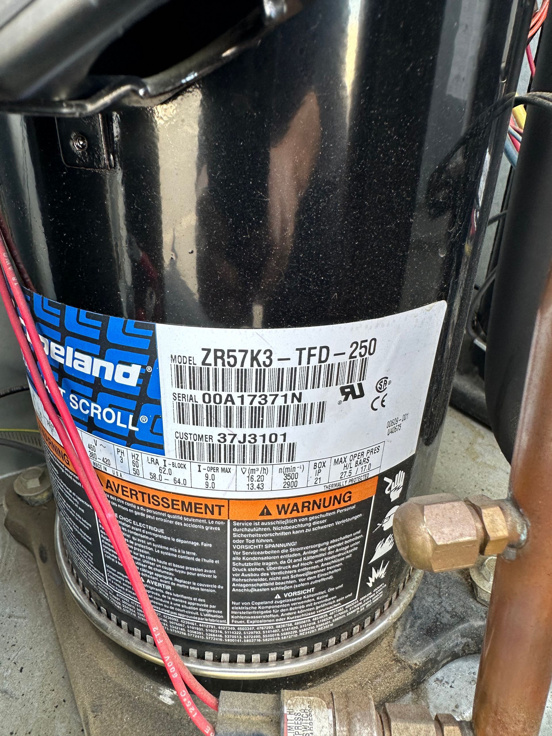 Black cylindrical compressor with label. Contains the model number: ZR57K3-TFD-250.