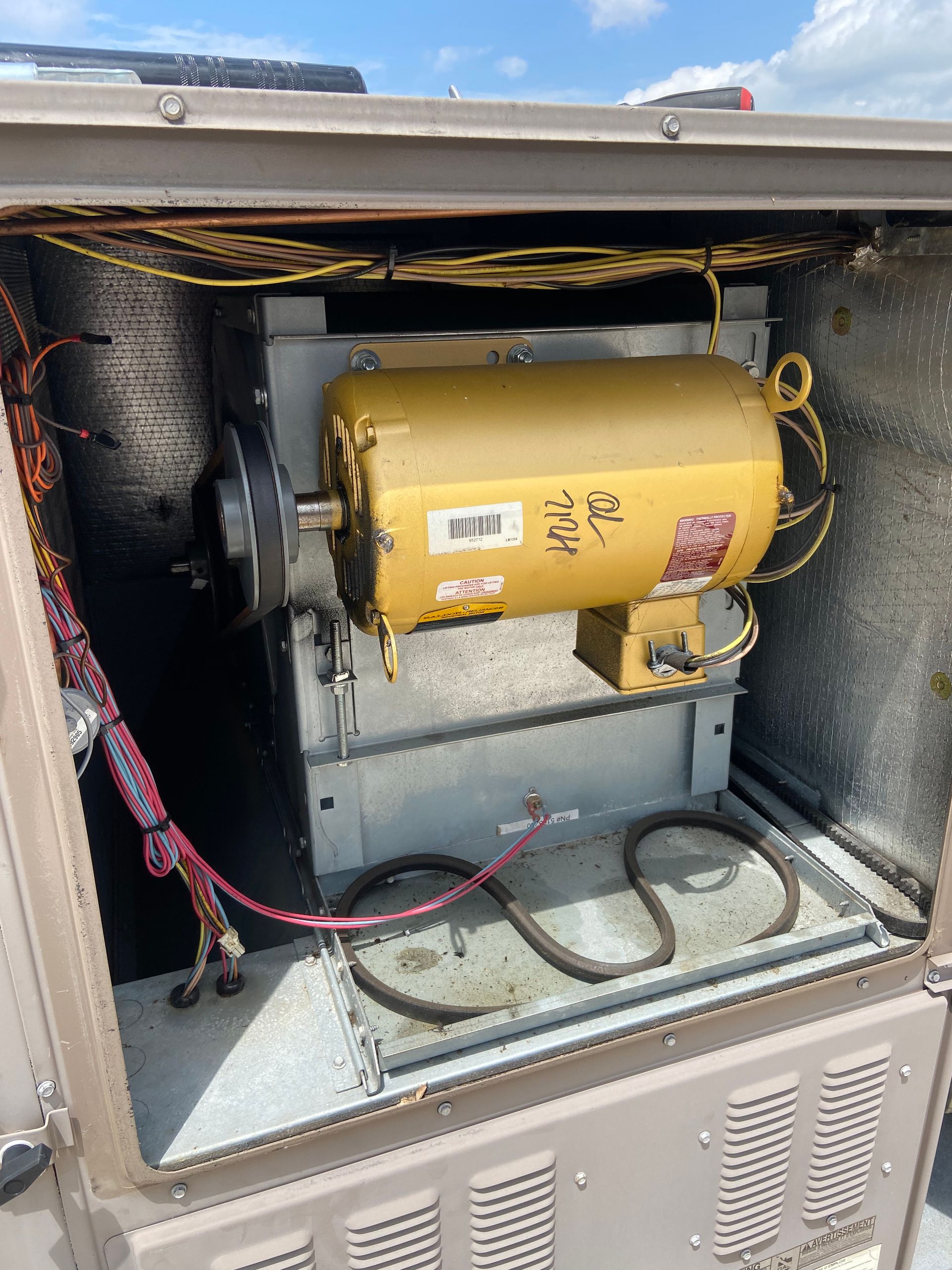 Yellow motor inside a metal HVAC unit; wires and components visible.