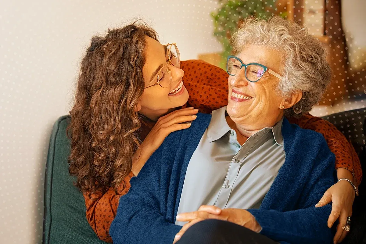 Família sentada num sofá numa sala de estar vendo um álbum de fotos.
