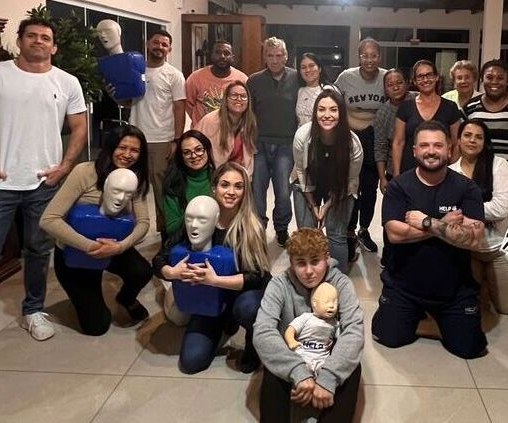 Equipe de especialistas da SmartSenior em um treinamento de RCP, praticando em manequins em ambientes fechados.