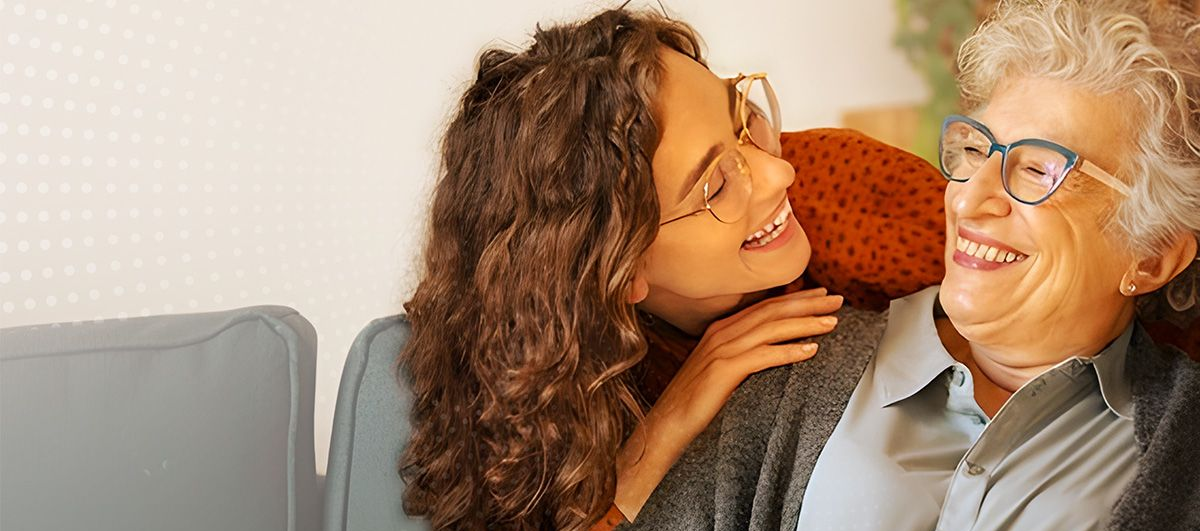 Família sentada num sofá numa sala de estar vendo um álbum de fotos.