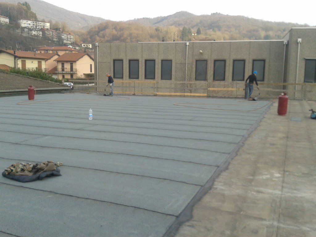 operai per messa in posa di strato impermeabile per tetto