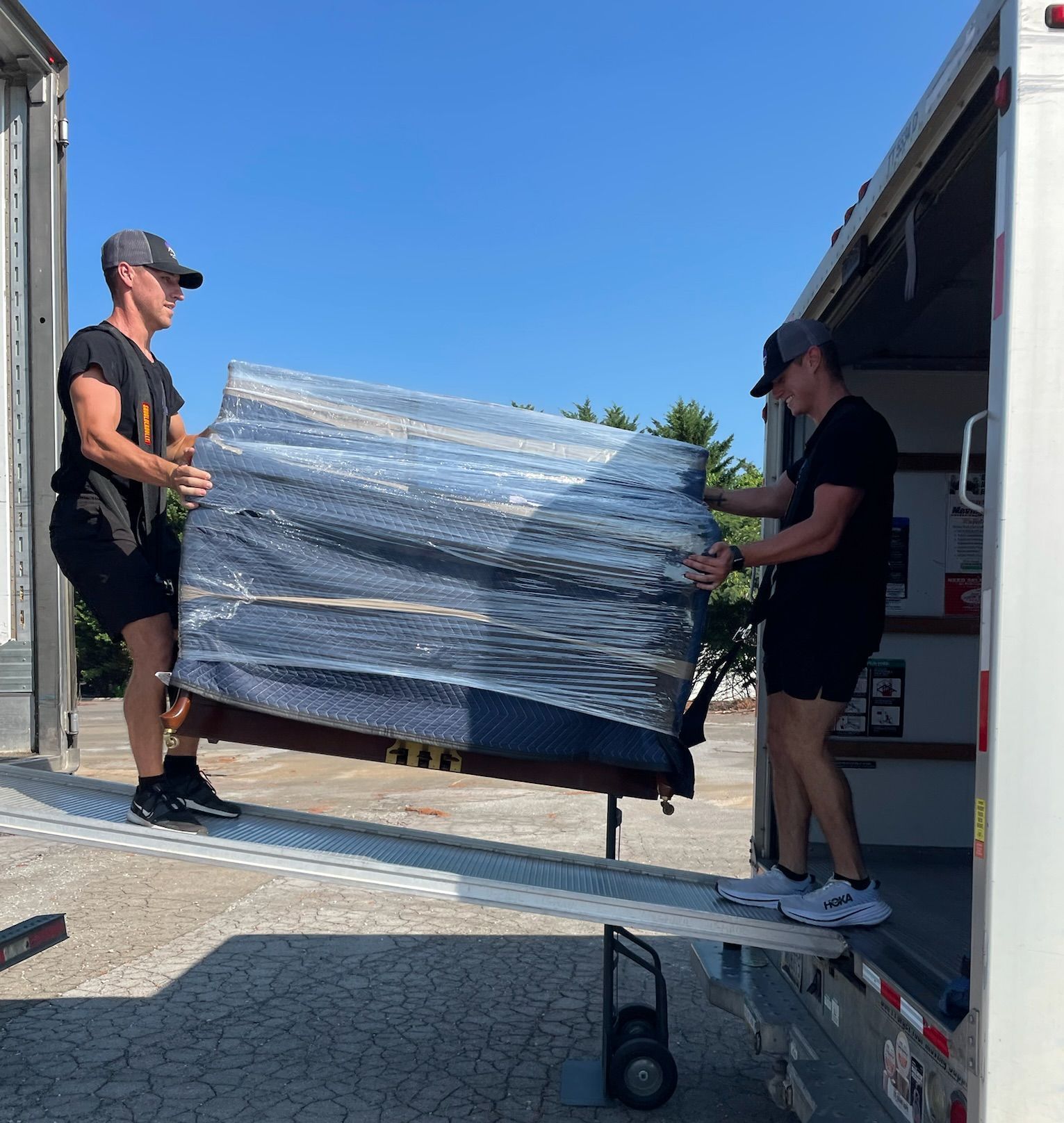 A road going through a field at sunset with the sun shining through the clouds.