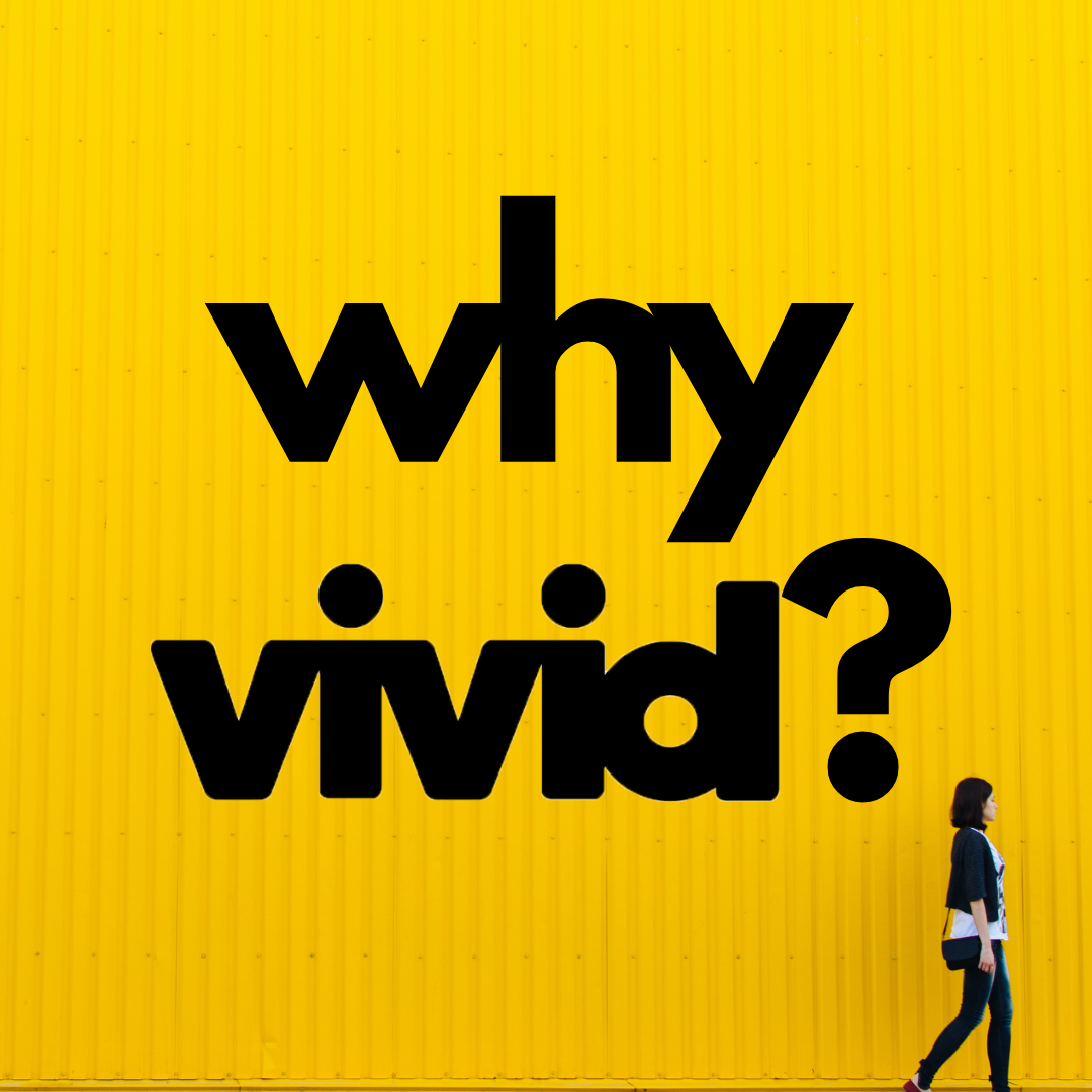 Bold black “why vivid?” text on a bright yellow wall with a person walking by