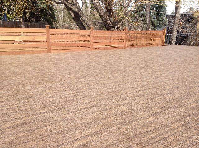 Grande terrasse couverte d'une membrane de PVC avec clôture en arrière-plan