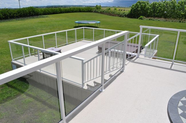 Une terrasse avec une balustrade blanche et un trampoline en arrière-plan