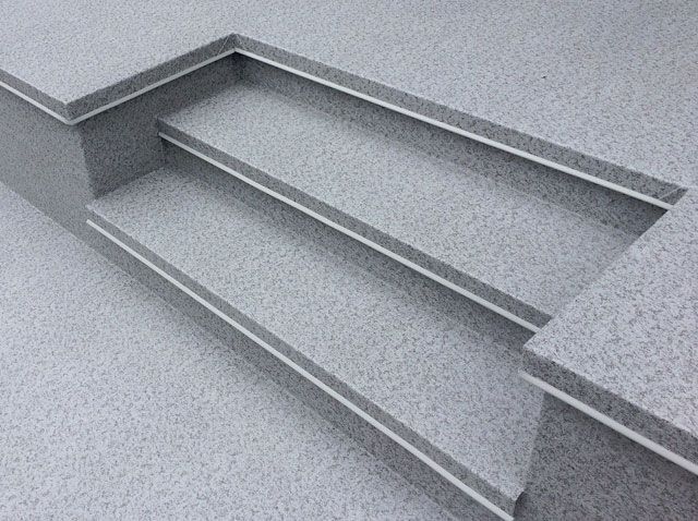 Un gros plan d'un escalier sur un sol en membrane de pvc.